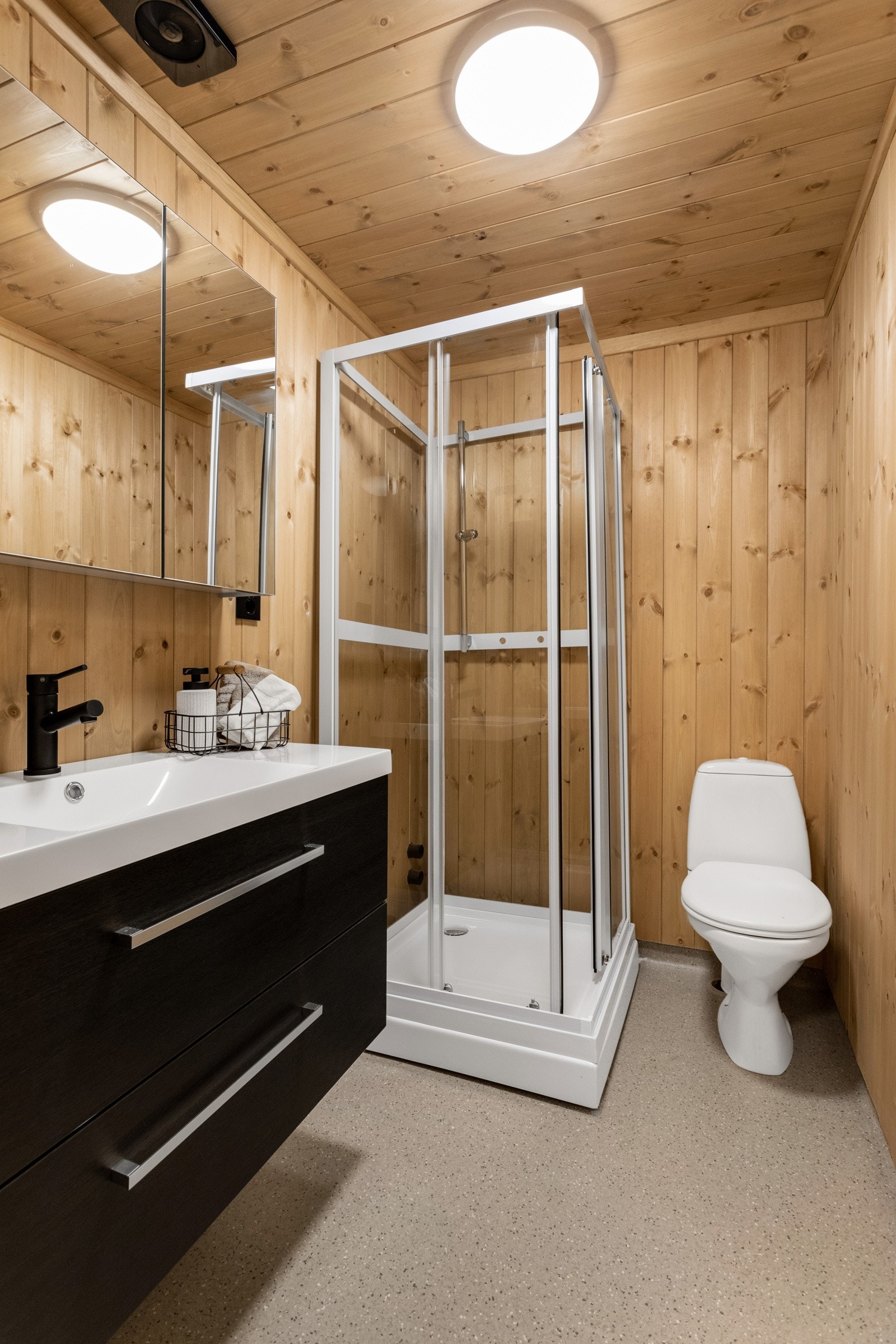 Badet er innredet med moderne innredning med hel servantplate, speilskap, dusjkabinett og toalett Galleribilde