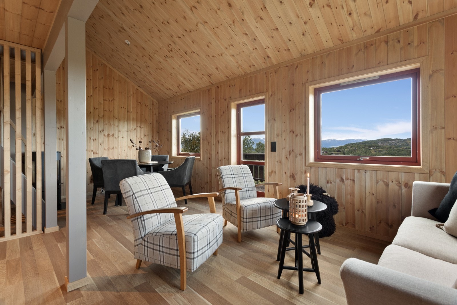 Stuen har gode vindusflater som bringer naturen rett inn i rommet Galleribilde