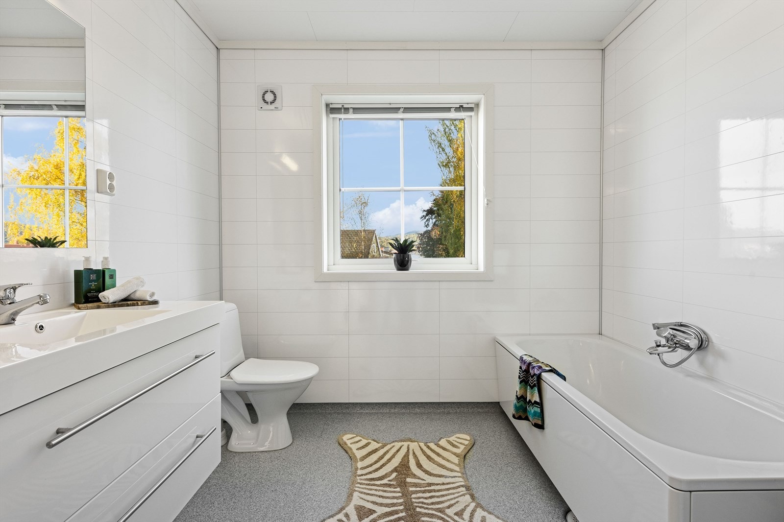 Badet er utstyrt med servant med underskap, speil, klosett og badekar. Galleribilde