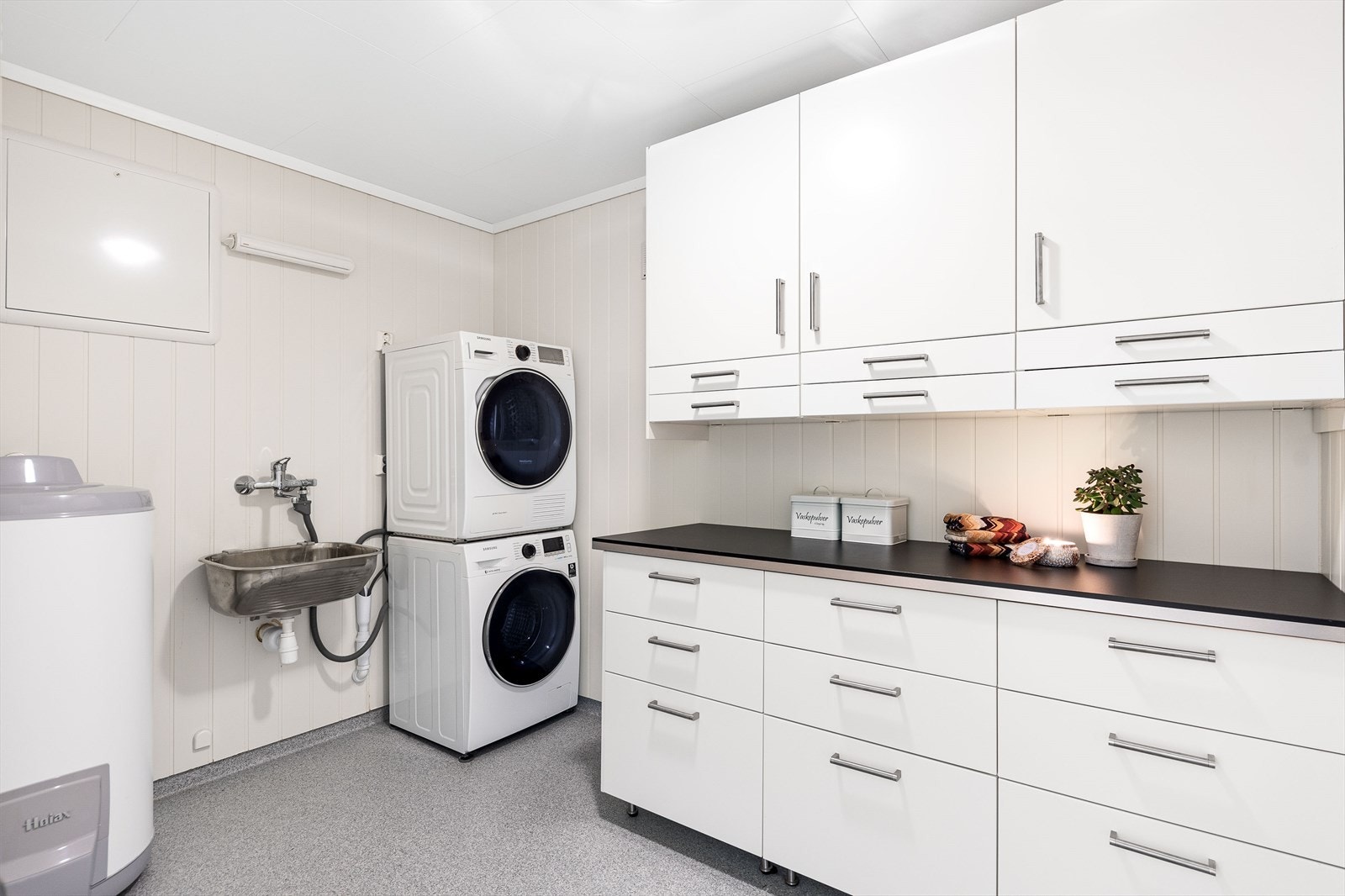 Meget praktisk og romslig vaskerom. Vaskerommet er utstyrt med utslagsvask, vv-tank, opplegg til vaskemaskin og tørketrommel, samt satt inn innredning med gode arbeidsflater. Galleribilde