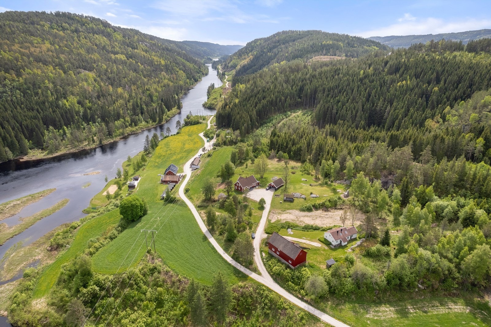 Boligen ligger idyllisk til på en høyde ved elven omgitt av et flott kulturlandskap og fin natur rett rundt Galleribilde