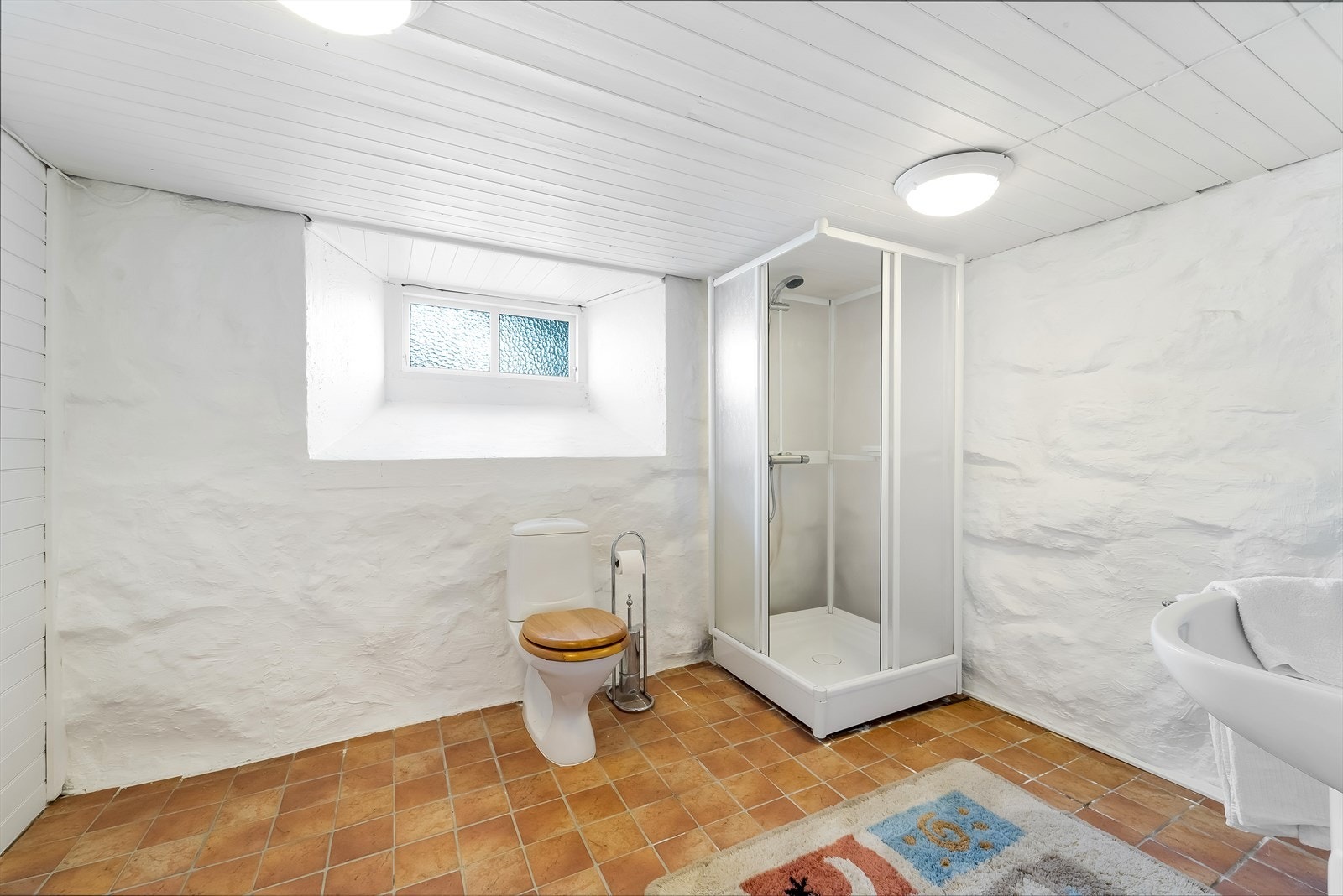 Bad i kjelleren med servant, toalett og dusjkabinett. Galleribilde