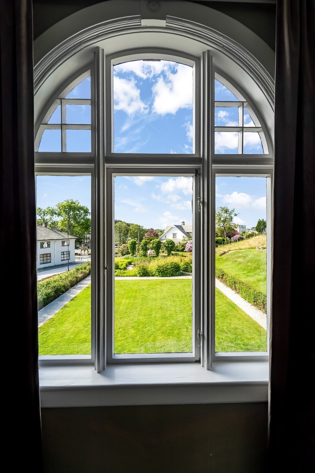 Utsikt fra ett av soverommene mot Vanse sentrum og hagen som er flott utformet. Galleribilde