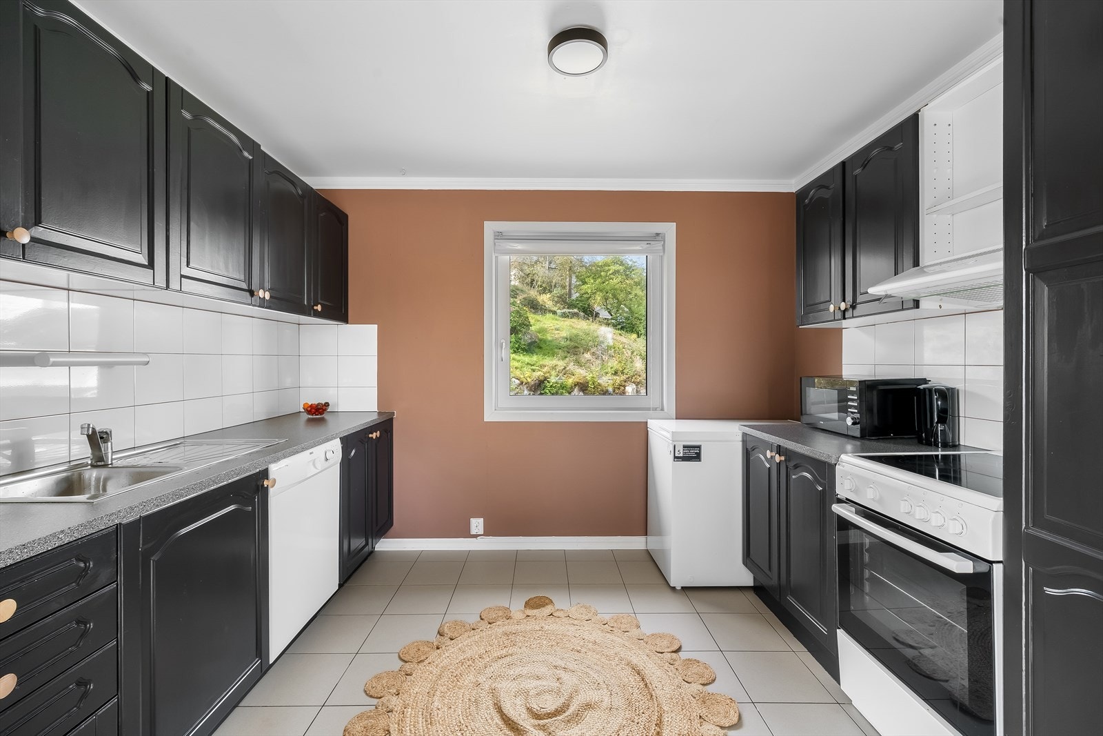 Pent profilert kjøkken med enkeltstående hvitevarer som medfølger. Galleribilde