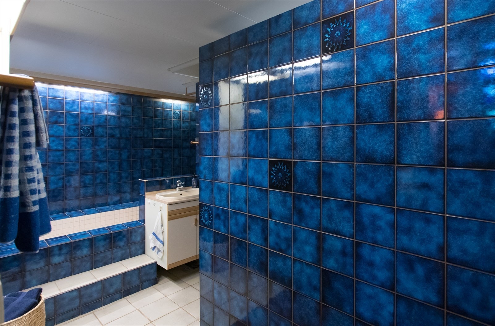 Fliselagt bad i underetasjen med baderomsinnredning, badekar og toalett. Galleribilde