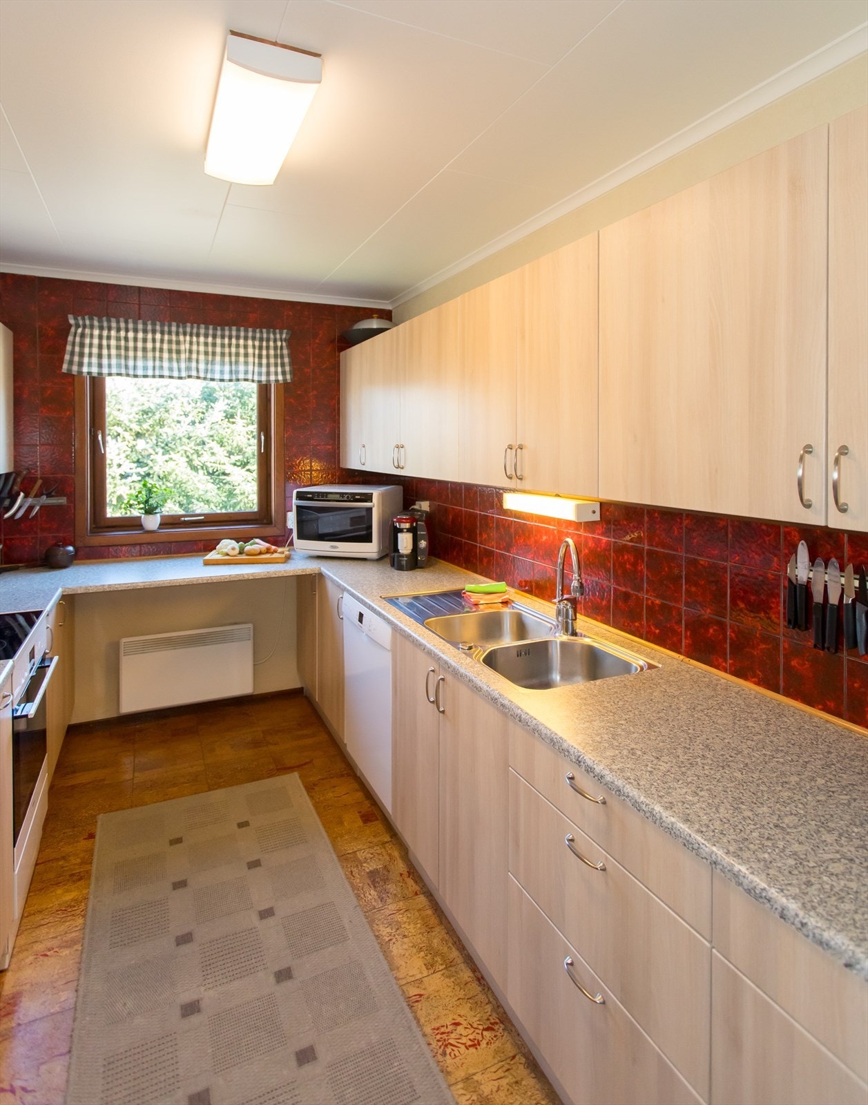 Hesteskoformet kjøkken med godt med benke- og skapplass. Galleribilde