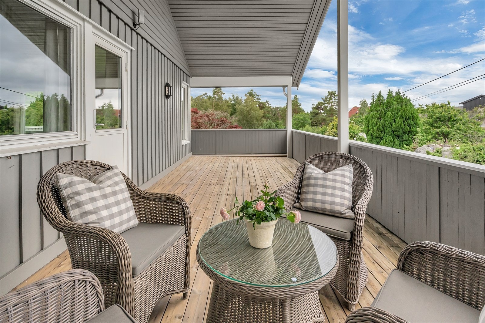 Delvis overbygd terrasse i 2. etasje ut fra stue med kveldssol Galleribilde