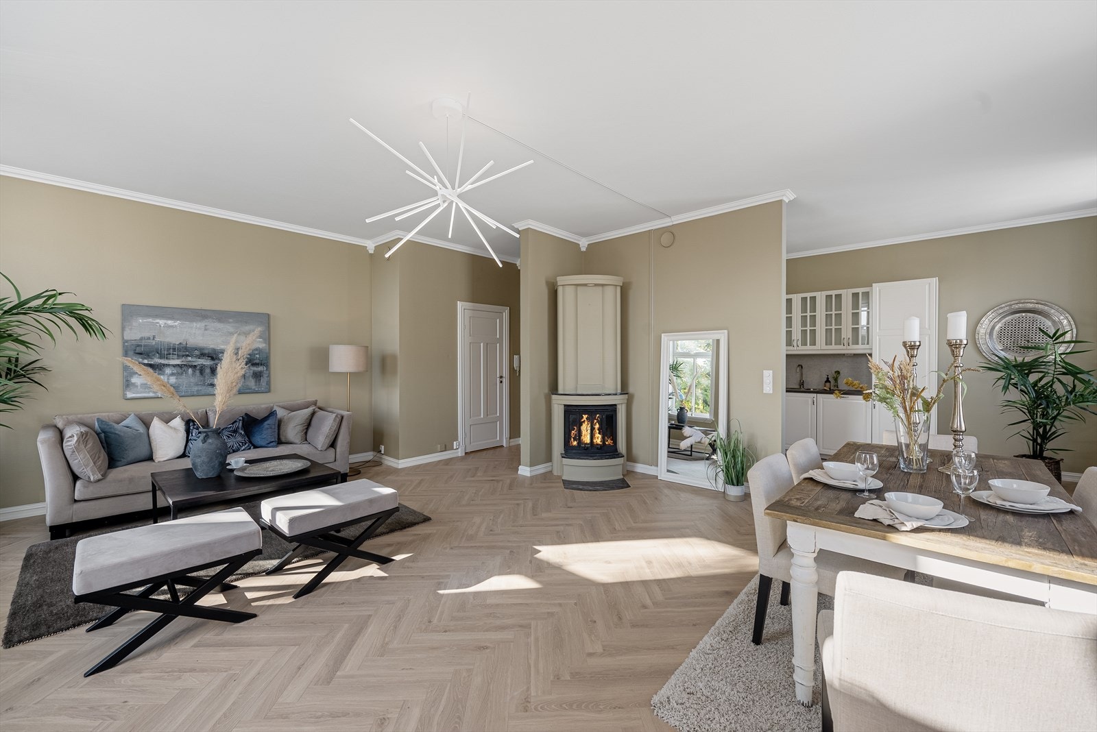 Stor stue med åpen kjøkkenløsning og god plass til spisestue med utsikt til peisen Galleribilde