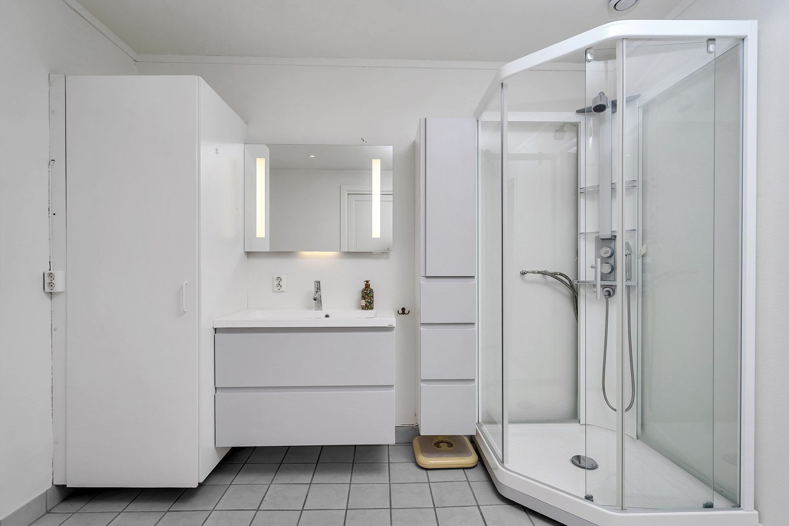 Bad utstyrt med toalett, dusjkabinett, servant og opplegg for vaskemaskin Galleribilde