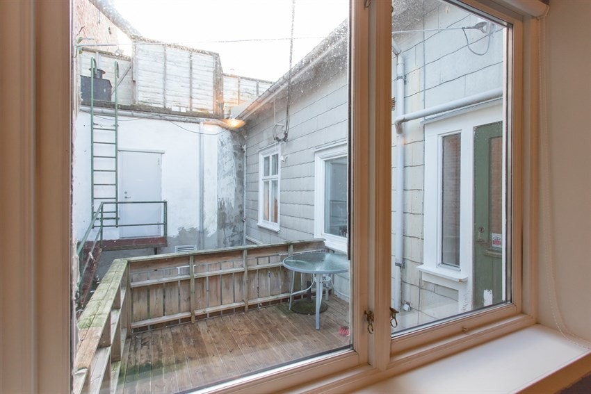 Fra ett av soverommene i leiligheten kan man se ut på balkongen i bakkant. Galleribilde