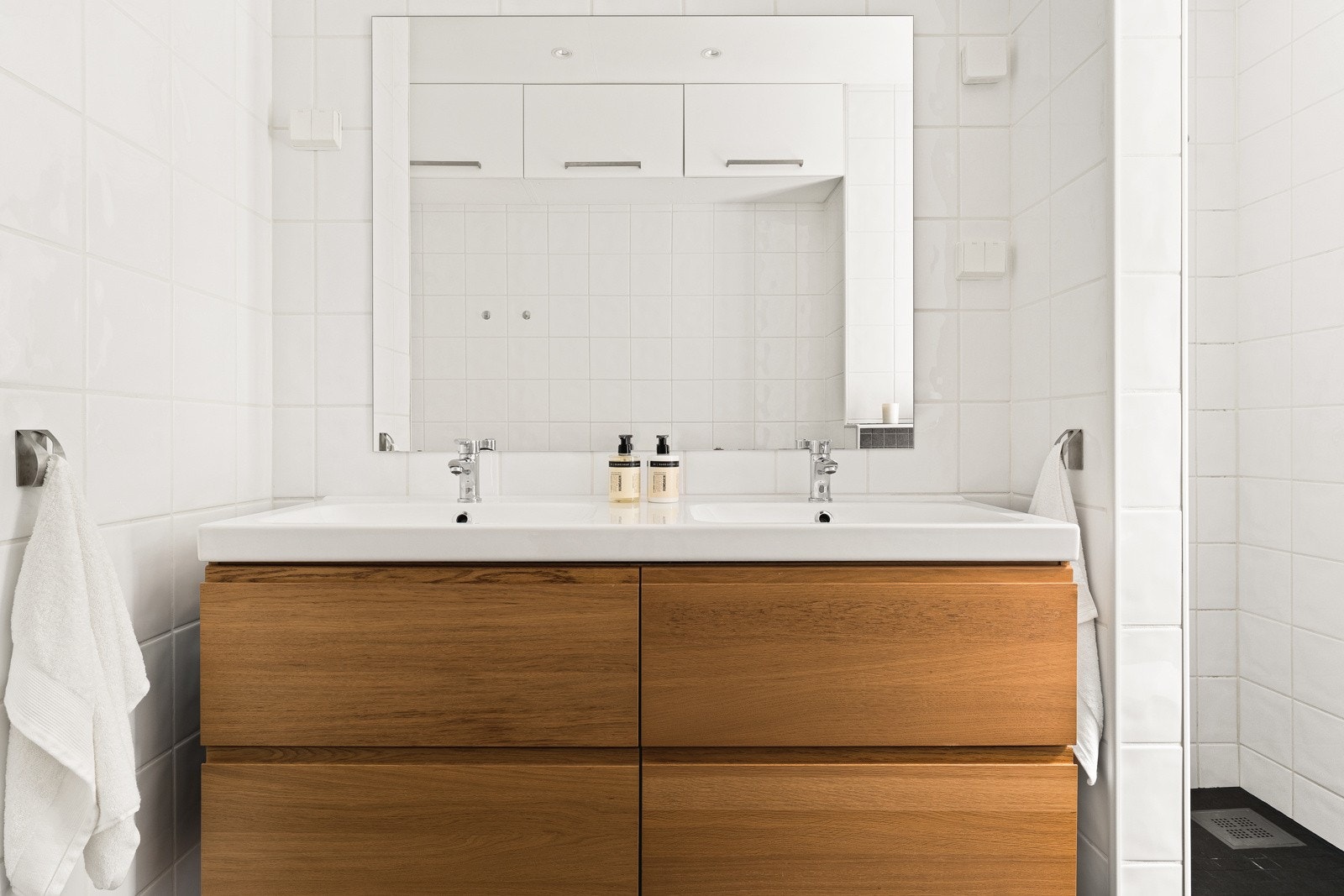 Badet inneholder praktisk dobbel servantinnredning, dusjnisje og vegghengt toalett. Galleribilde