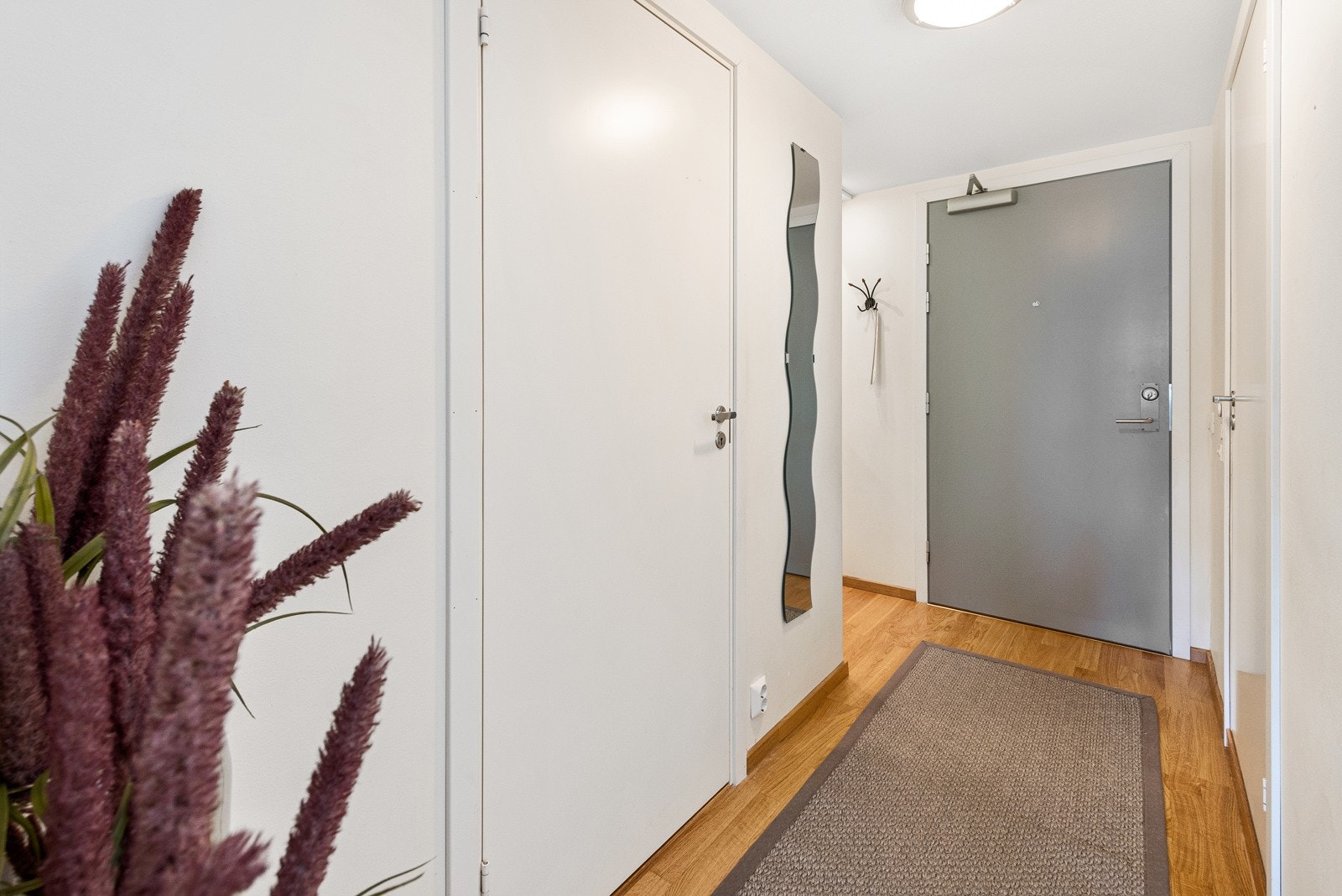 I leilighetens entré er det plass til både garderobeskap og andre oppbevaringsløsninger i form av klesknagger og kommode. Galleribilde