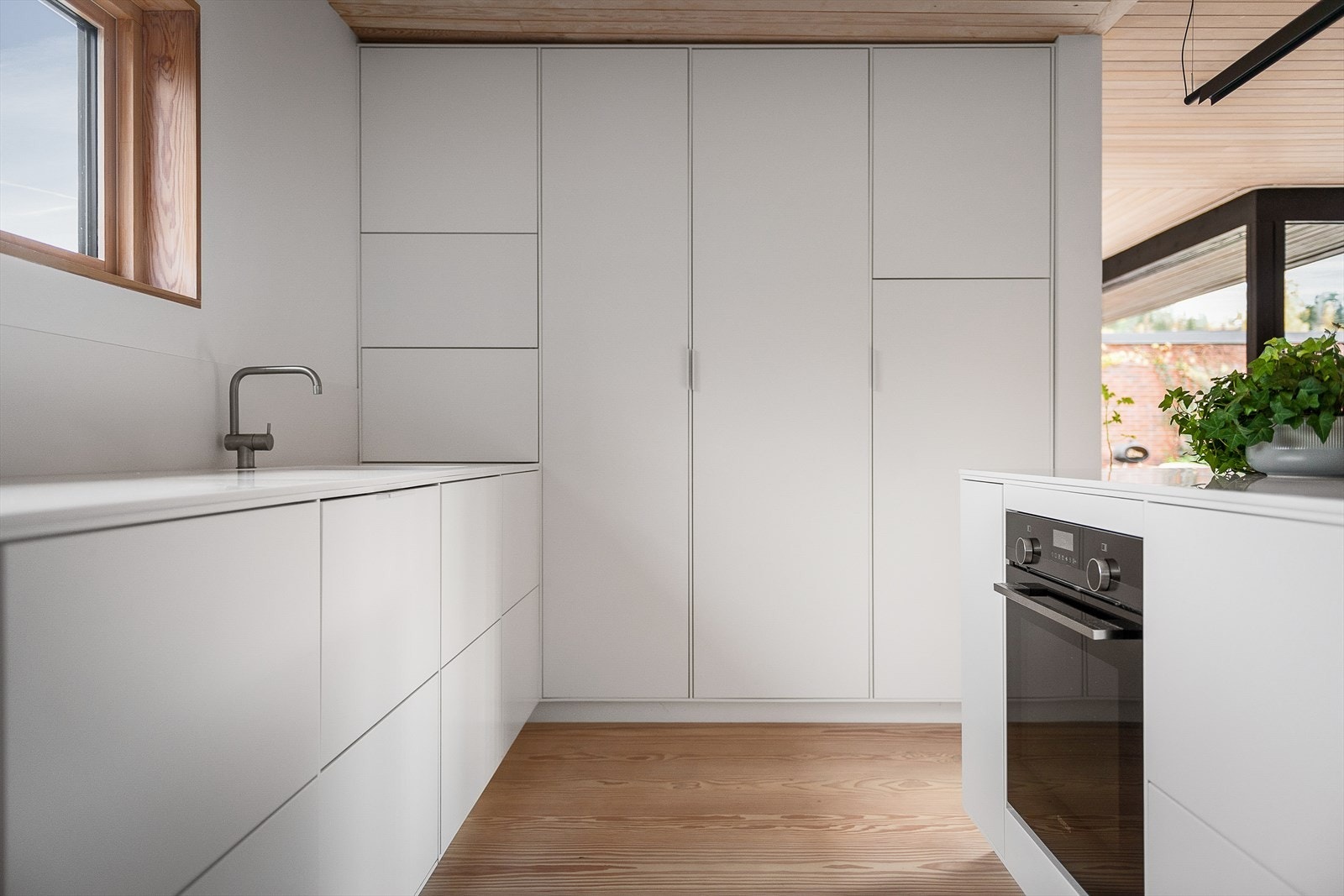 Benkeplater og splash-kant i Corian. Integrert oppvaskkum med bunn i rustfritt stål. Blandebatteri i børstet stål fra Vola. Galleribilde