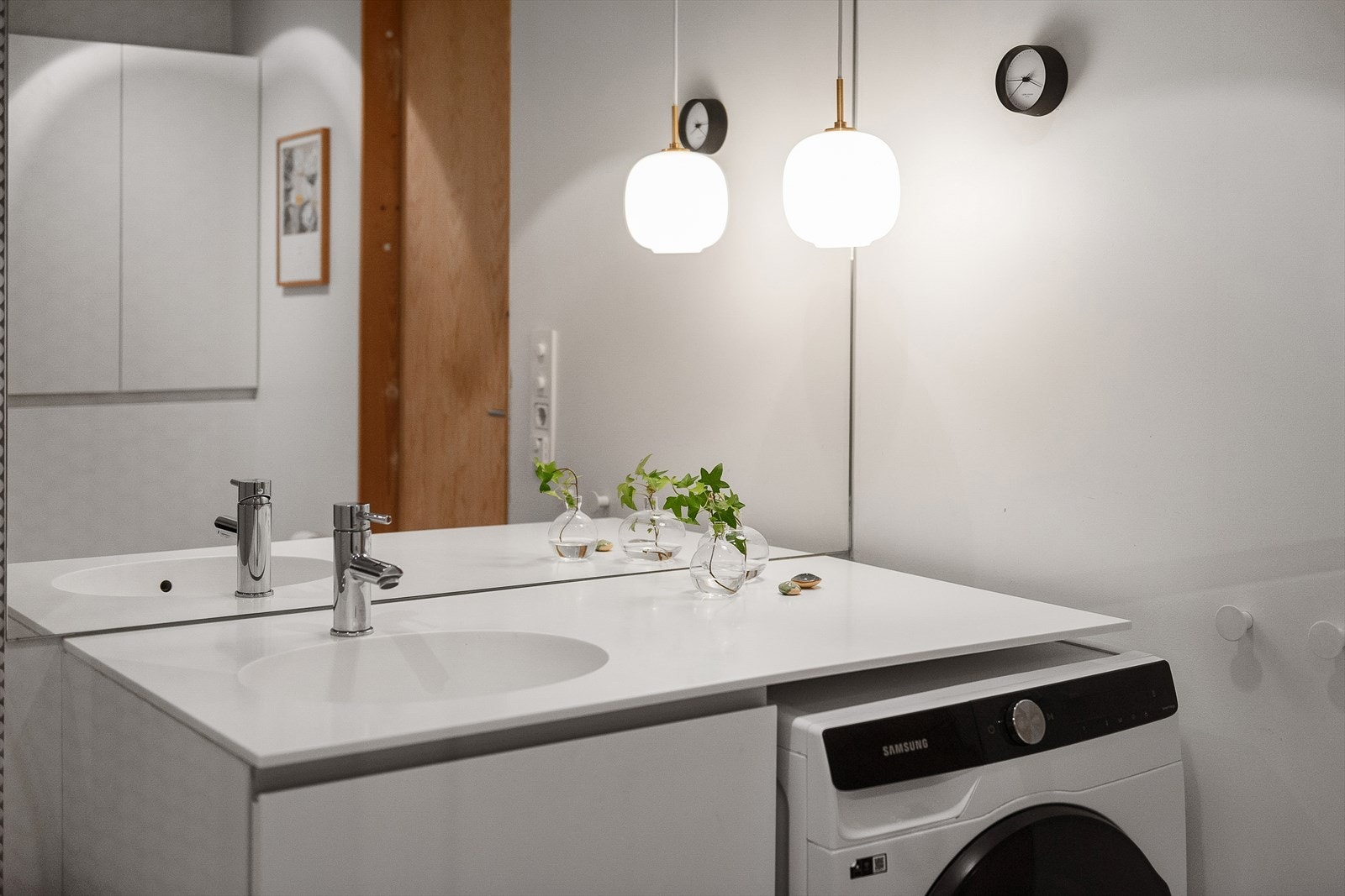 Benkeplate i Corian med integrert servant. Stort speil og oppbevaring under servant. Opplegg for vaskemaskin. Galleribilde