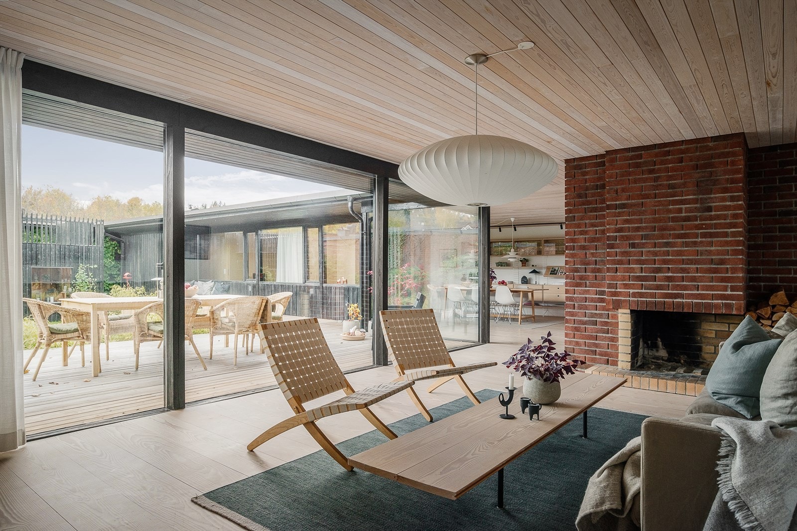 Stuen har en lun atmosfære med både gulvvarme, vedkamin og en åpen peis i rød teglstein. Galleribilde