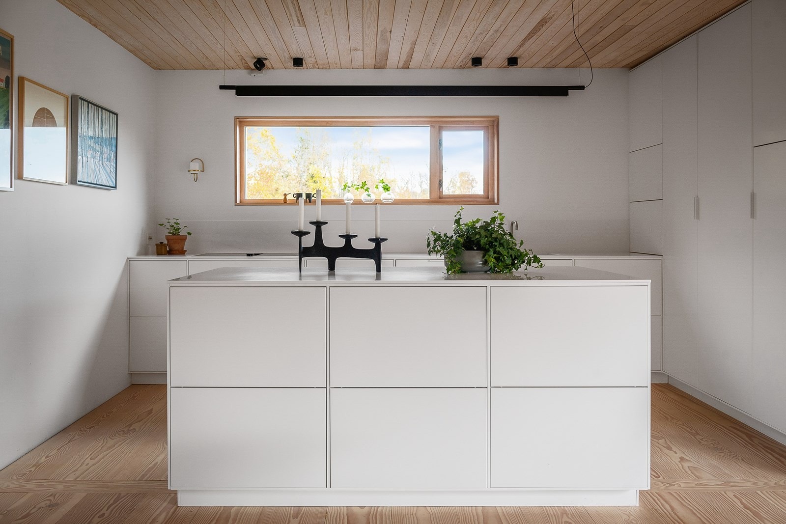 Innredningen har treinventar, hvite, glatte fronter i matt utførelse, store høyskap og servodrive for avfallshåndtering. Galleribilde