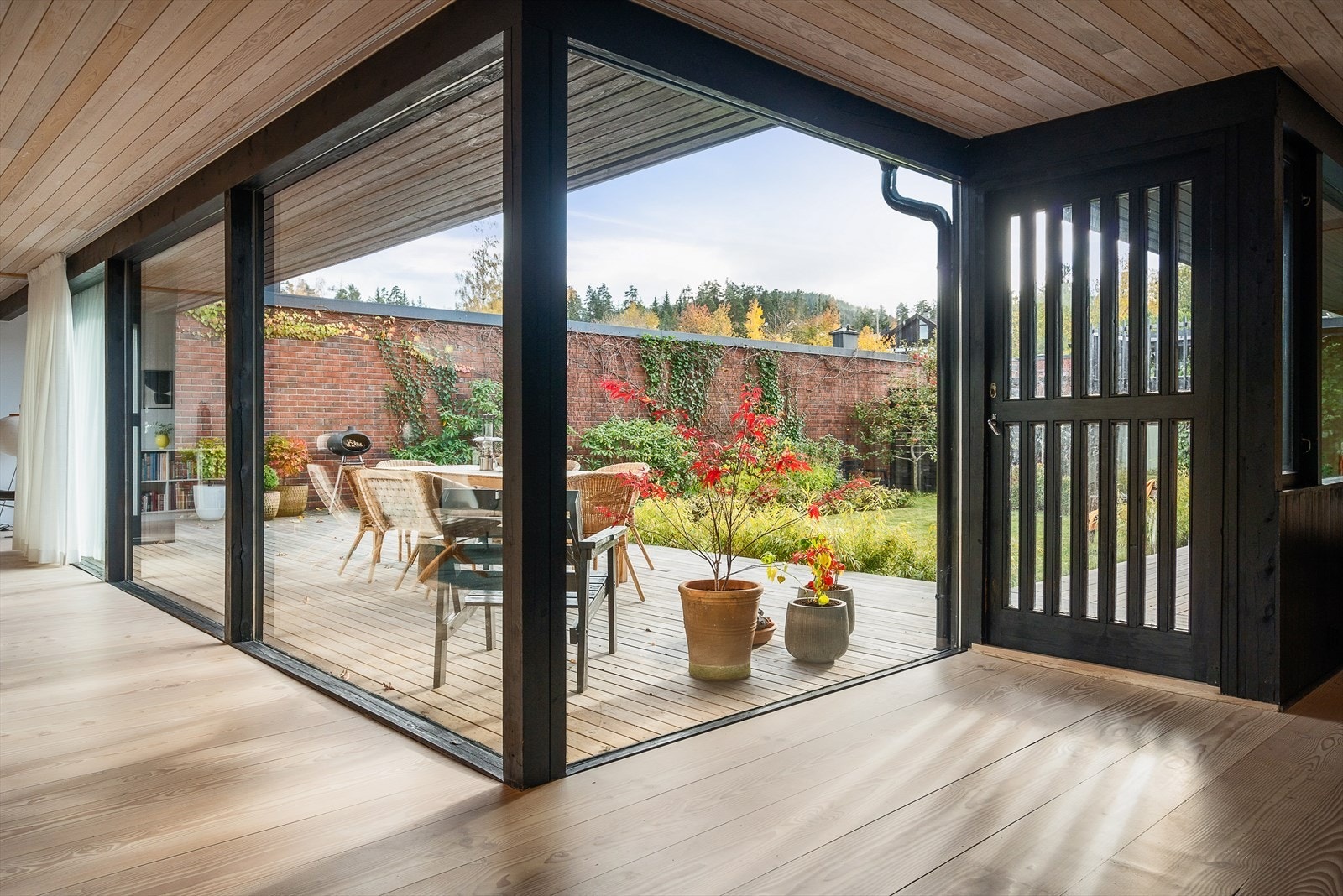 Store vindusflater, gulv og himling som flukter med terrasse og takoverheng visker ut grensen mellom ute og inne. Galleribilde