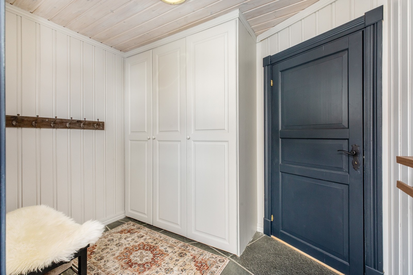 Entré med flislagt gulv og varmekabler. Plassbygd garderobeskap til yttertøy og sko Galleribilde