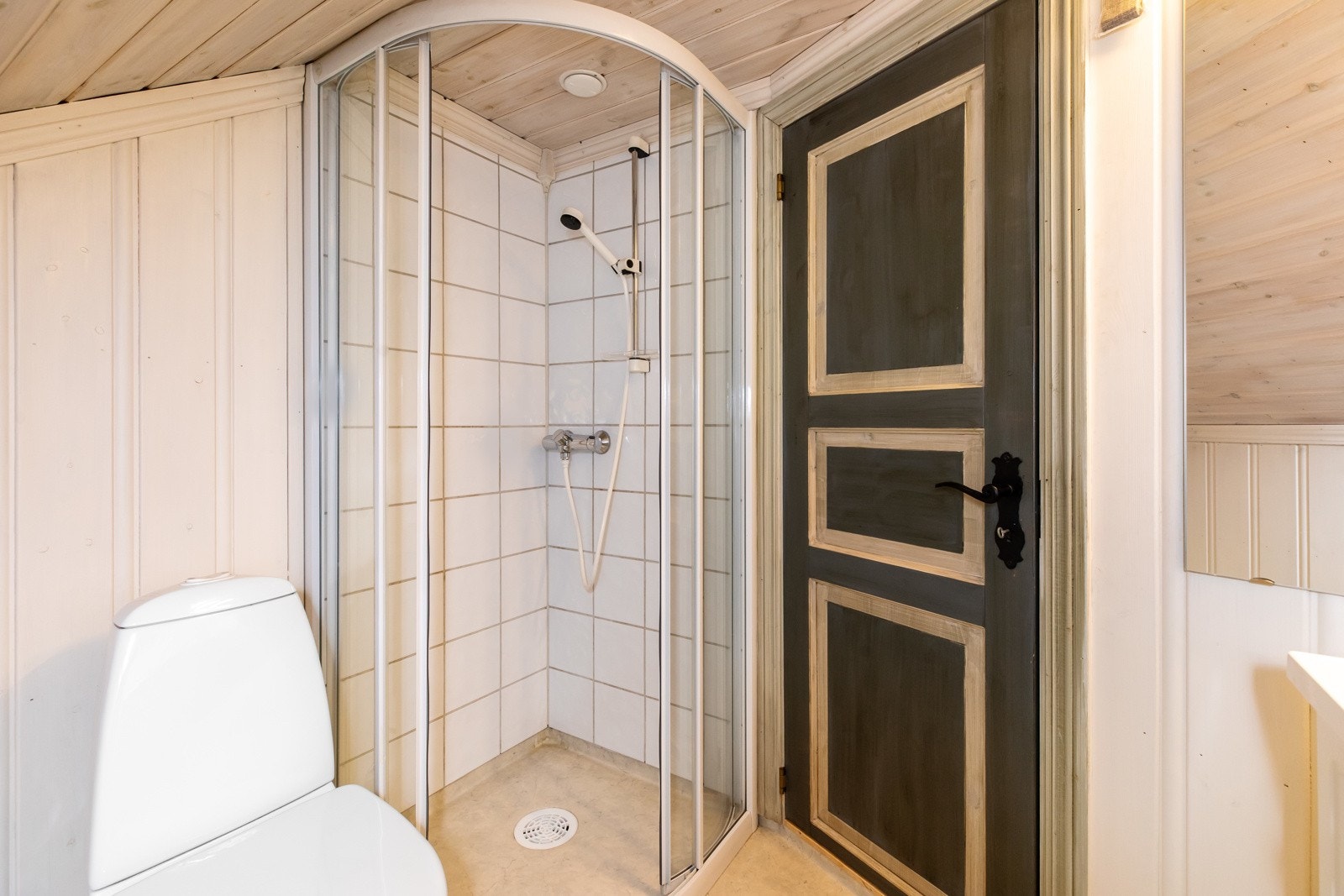 Badet oppe på loftetasjen har malt panel på veggene og belegg på gulv Galleribilde