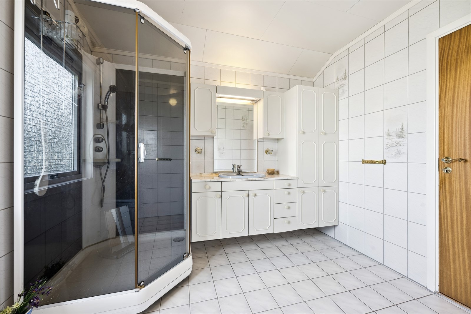 Badet er fra 1986 med fliser på gulv og varmekabler Galleribilde