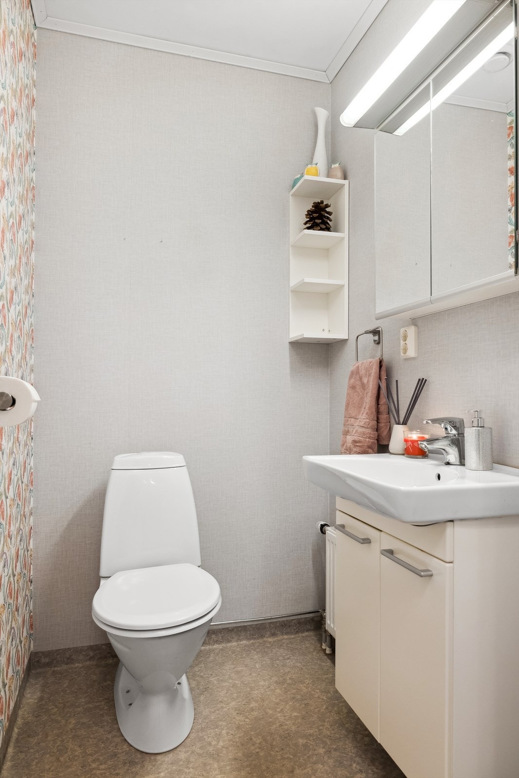 Toalettrommet er innredet med gulvstående toalett, servantskap med heldekkende servant og speil med lys. Rommet har radiator. Galleribilde