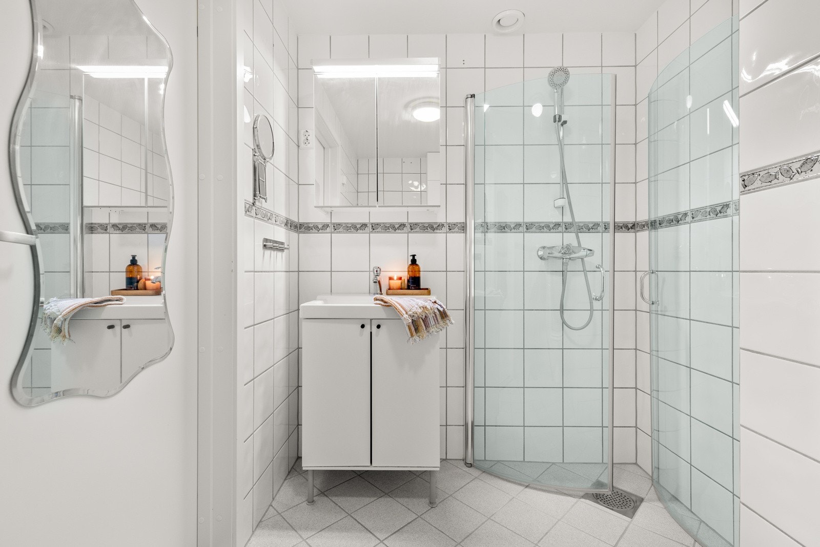 Badet er utstyrt med wc, dusjhjørne, servant m/skap og opplegg for vaskemaskin. Galleribilde