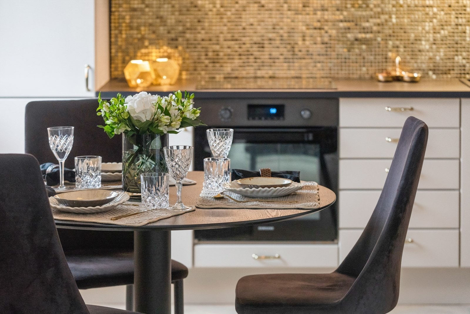 I 2021 ble veggen over kjøkkenbenken beskyttet med lekker gullmosaikk som står godt til resten av interiøret. Galleribilde