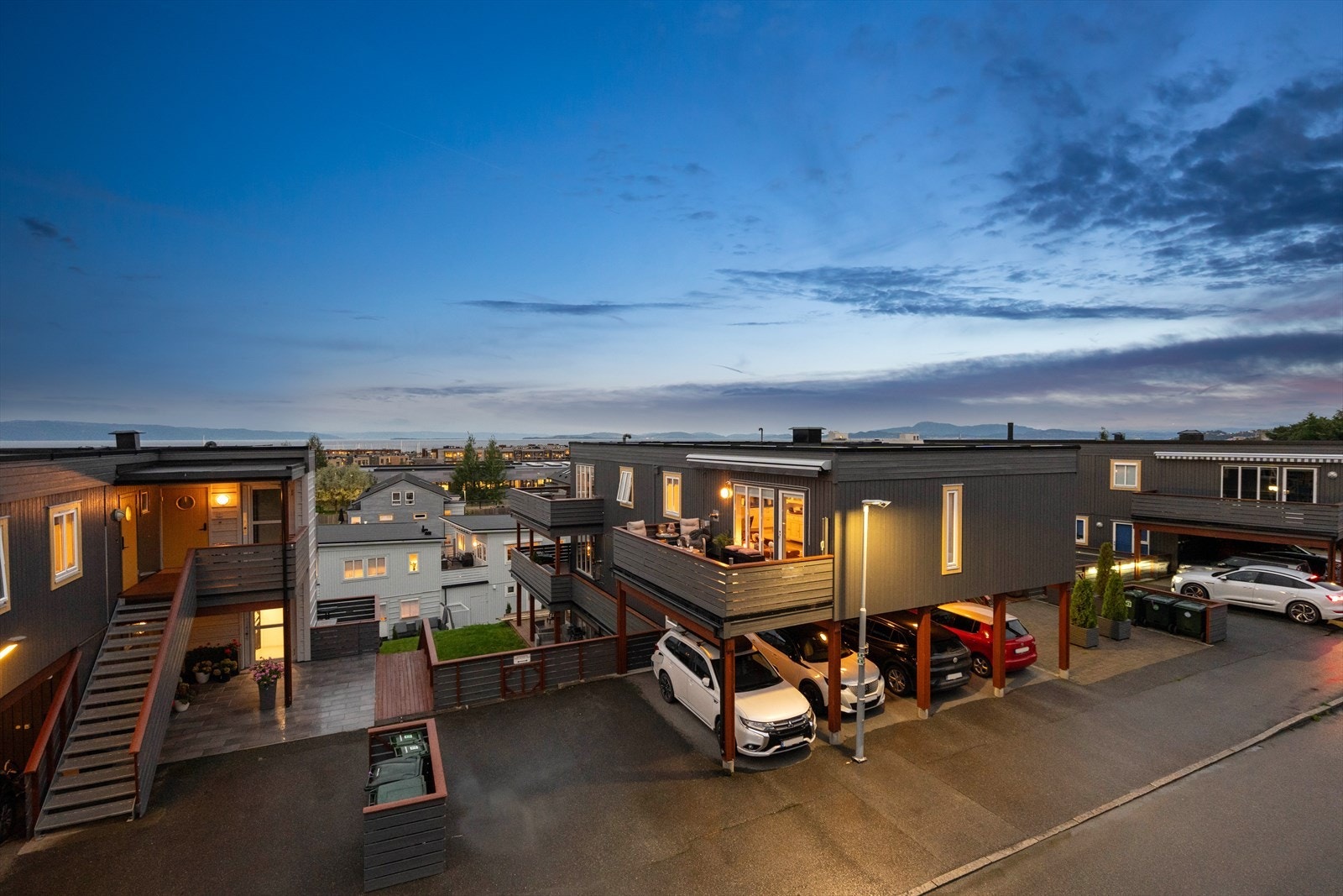 Det er parkering i carport og på asfaltert gårdsplass. Galleribilde