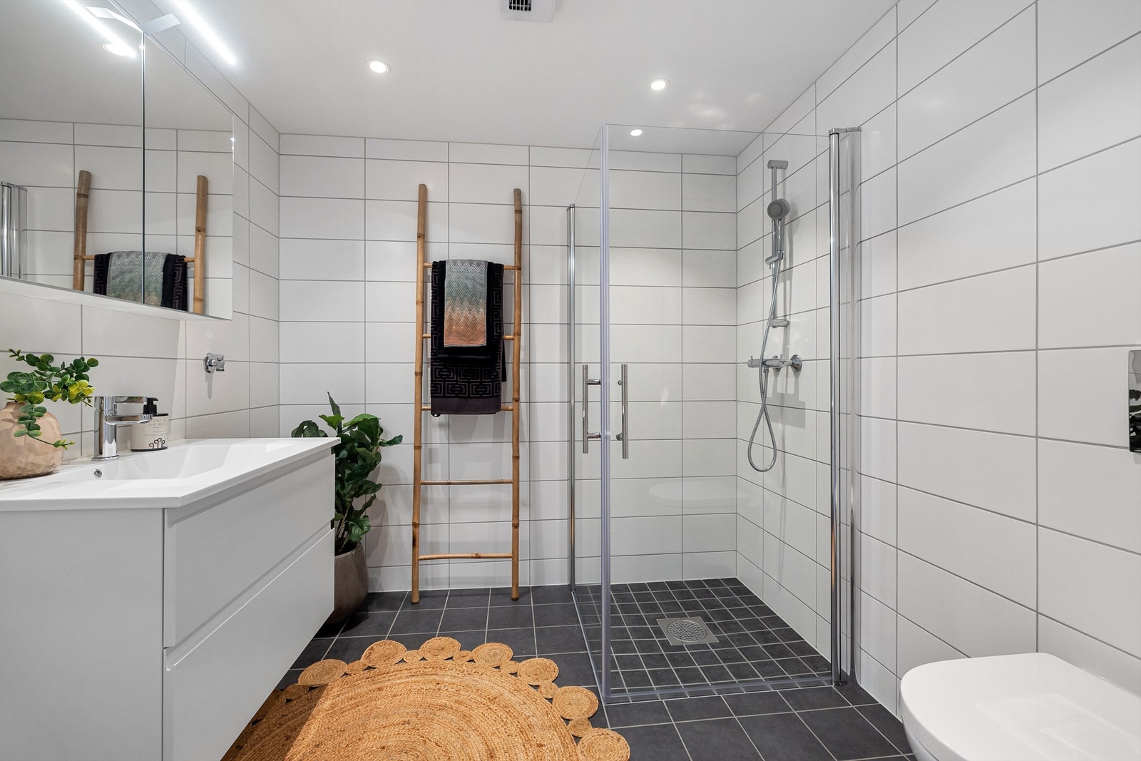 Pent flislagt bad med veggmonterte dusjdører Galleribilde