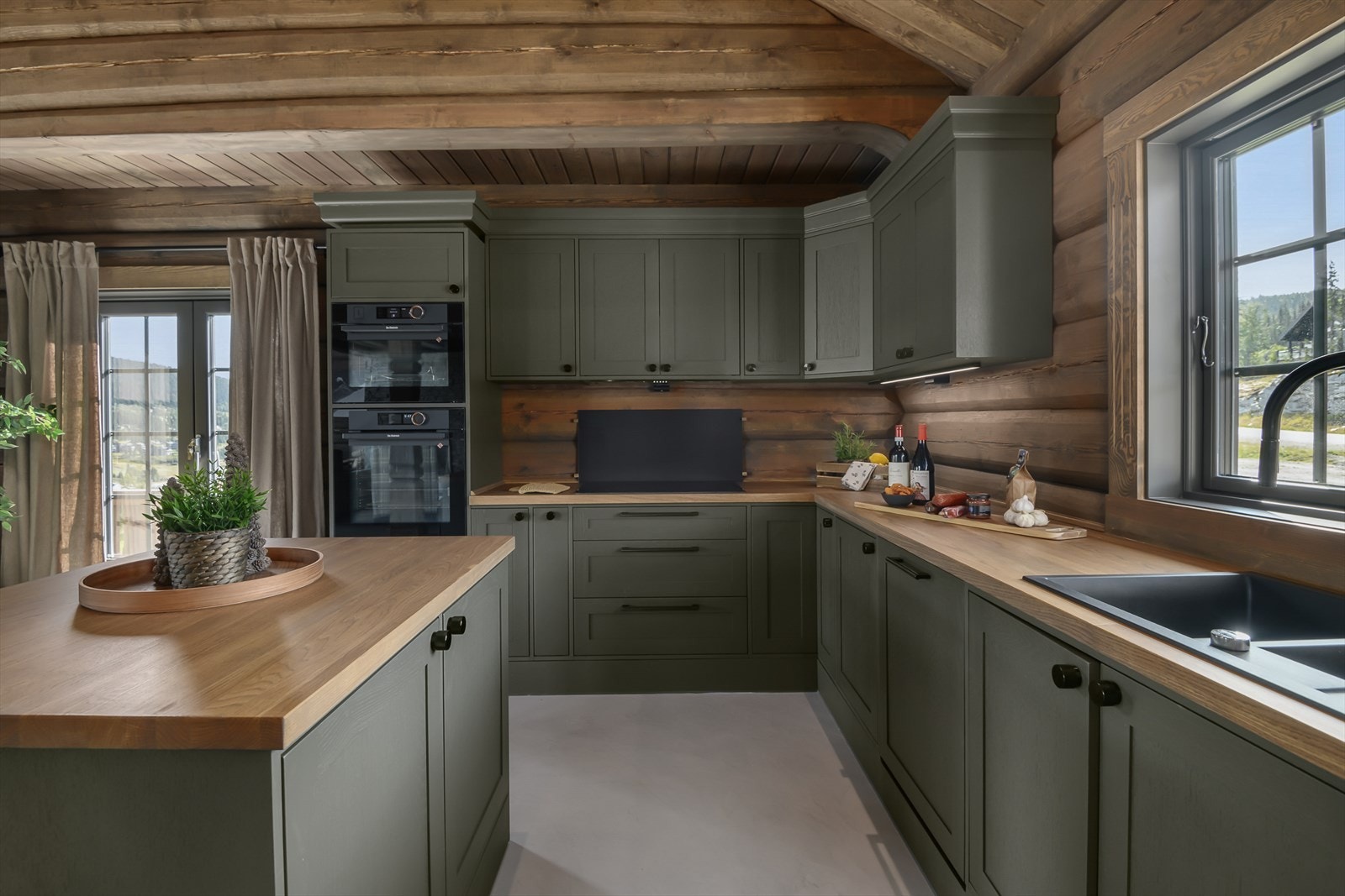 Det er valgt et lekkert, velutstyrt og moderne kjøkken som står godt til de tradisjonelle tømmerveggene. Galleribilde