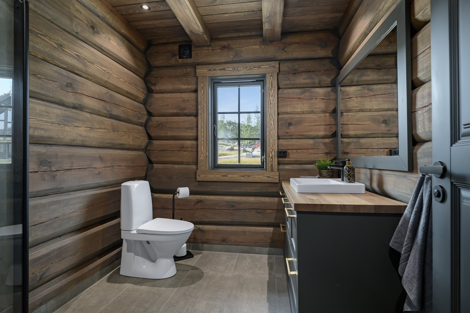 Bad med flislagt gulv. Gulvmontert WC. Galleribilde