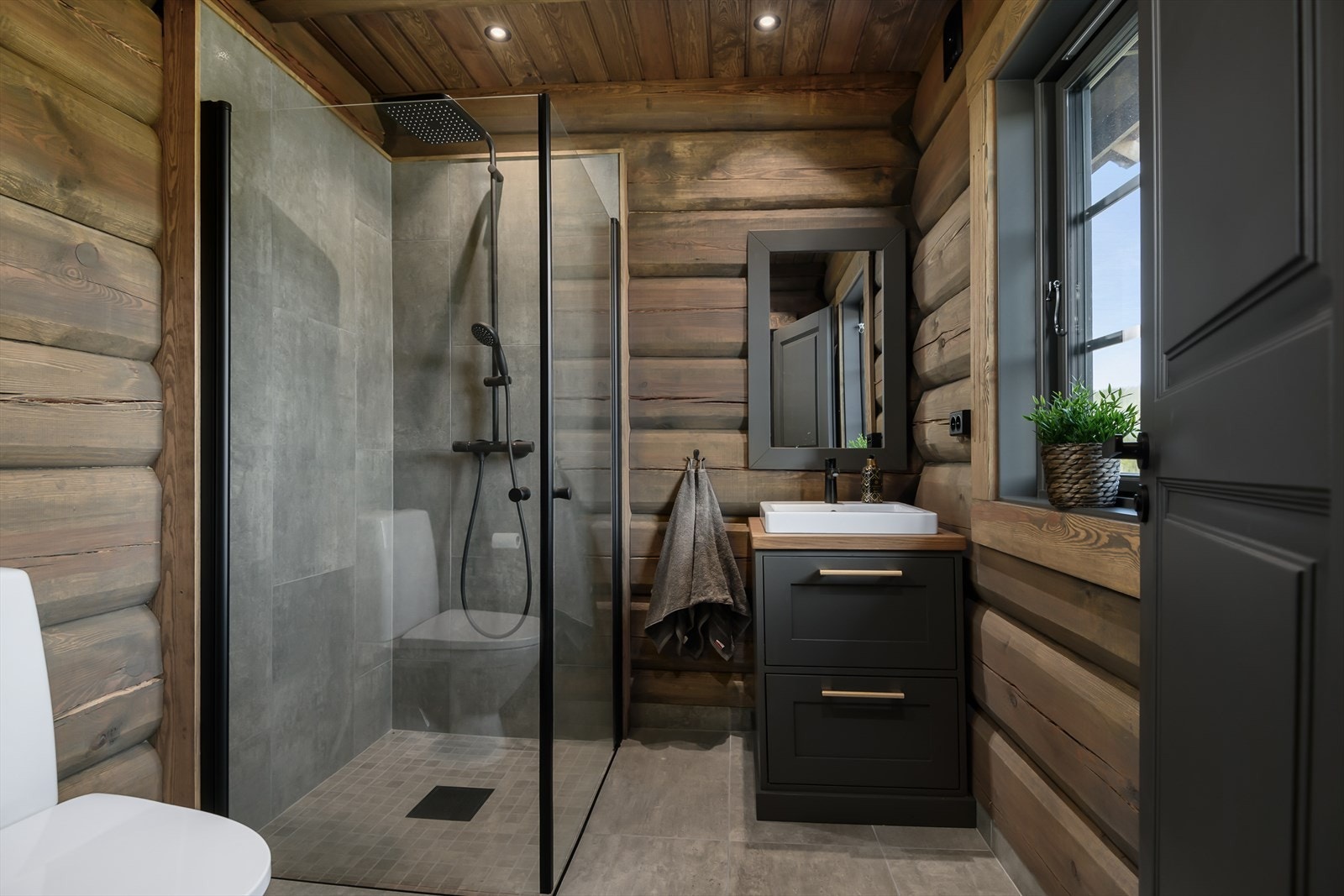 Fra badet tilhørende hovedsoverommet. Dusj, enkel servantinnredning med skuffer og WC. Galleribilde