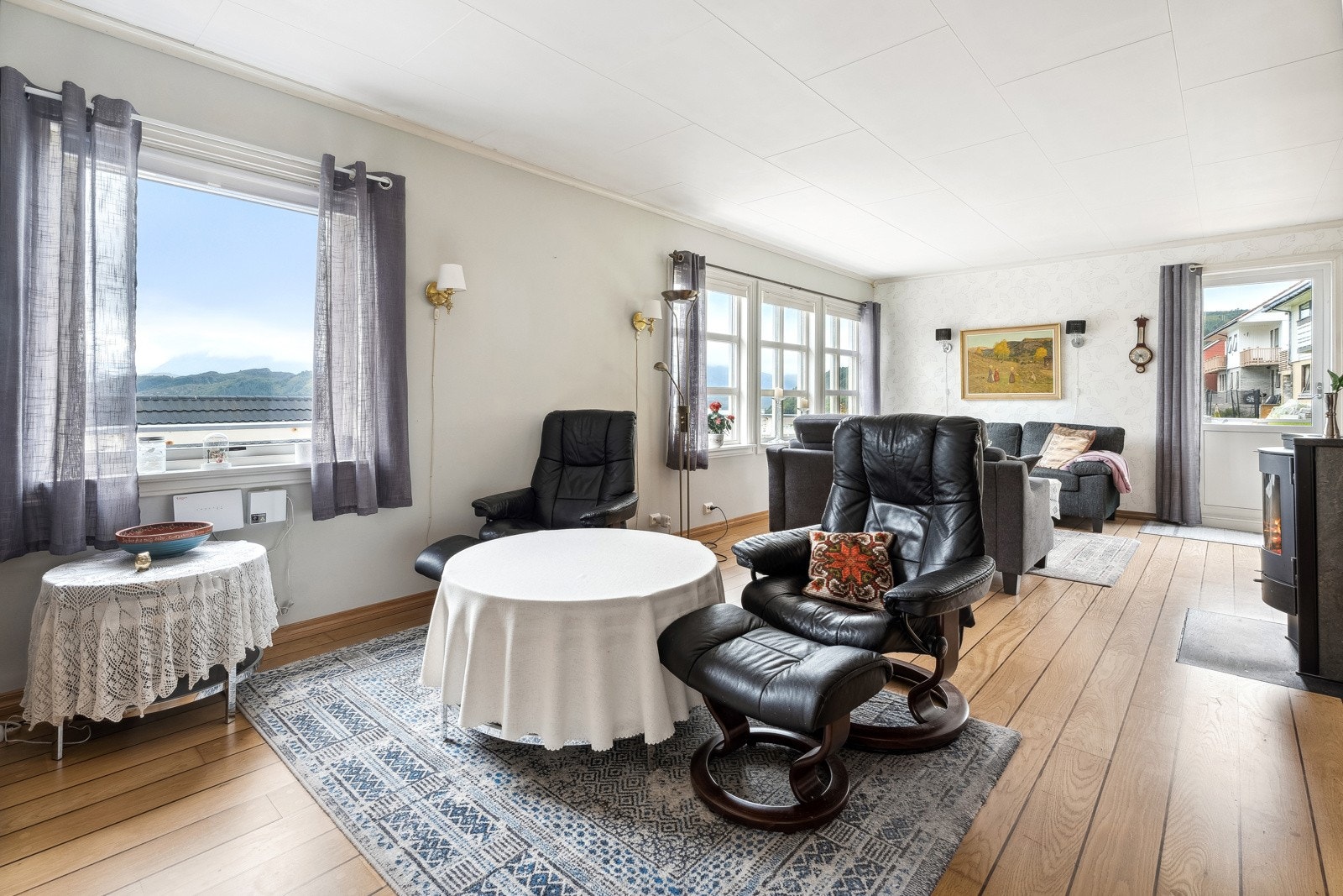 Lys og innbydende stue med store vindusflater Galleribilde