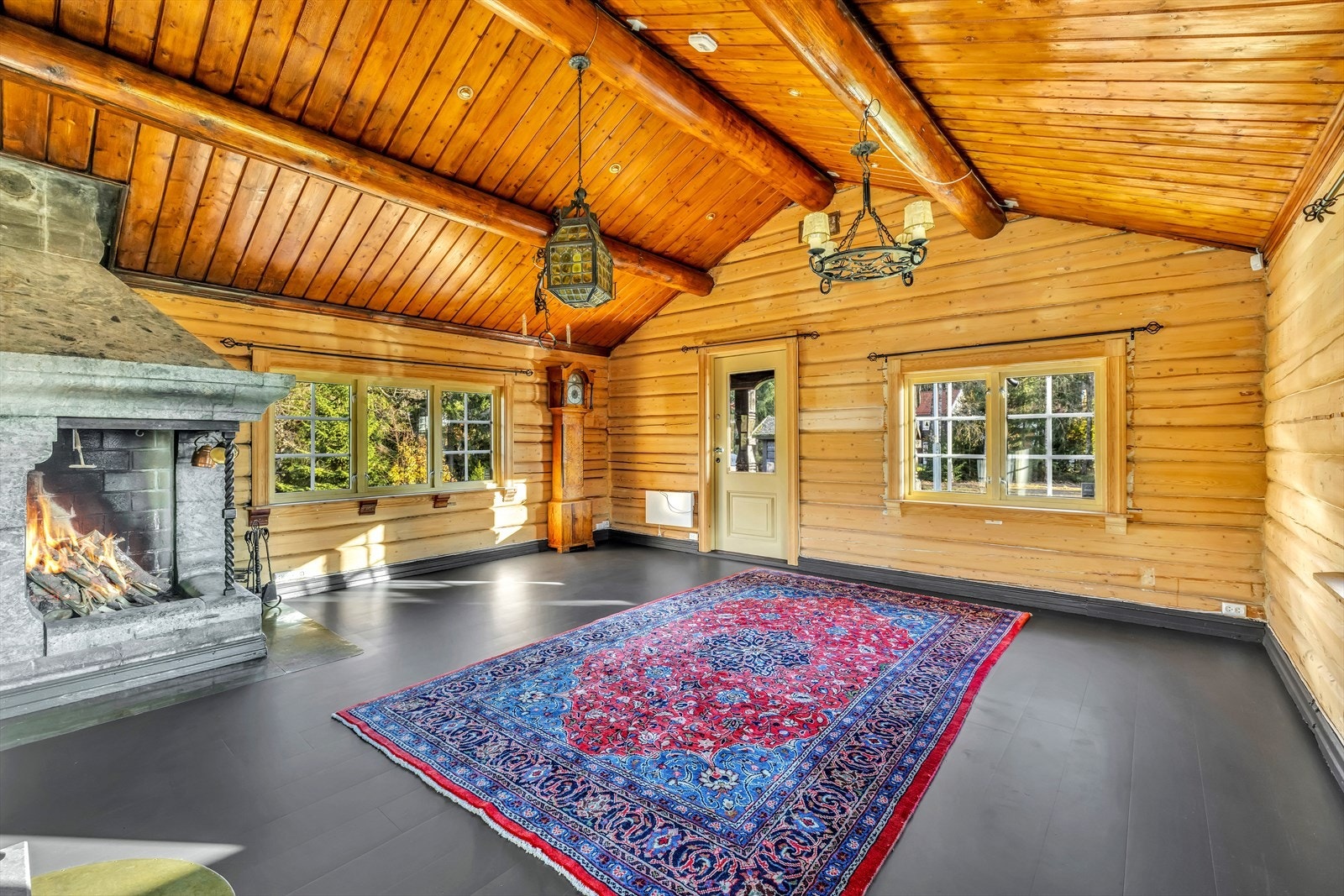 Stuen i første etasje har både en vakker kleberstein åpen peis og en kleberstein ovn. Det er utgang til en liten balkong og videre til hagen fra stuen. Galleribilde