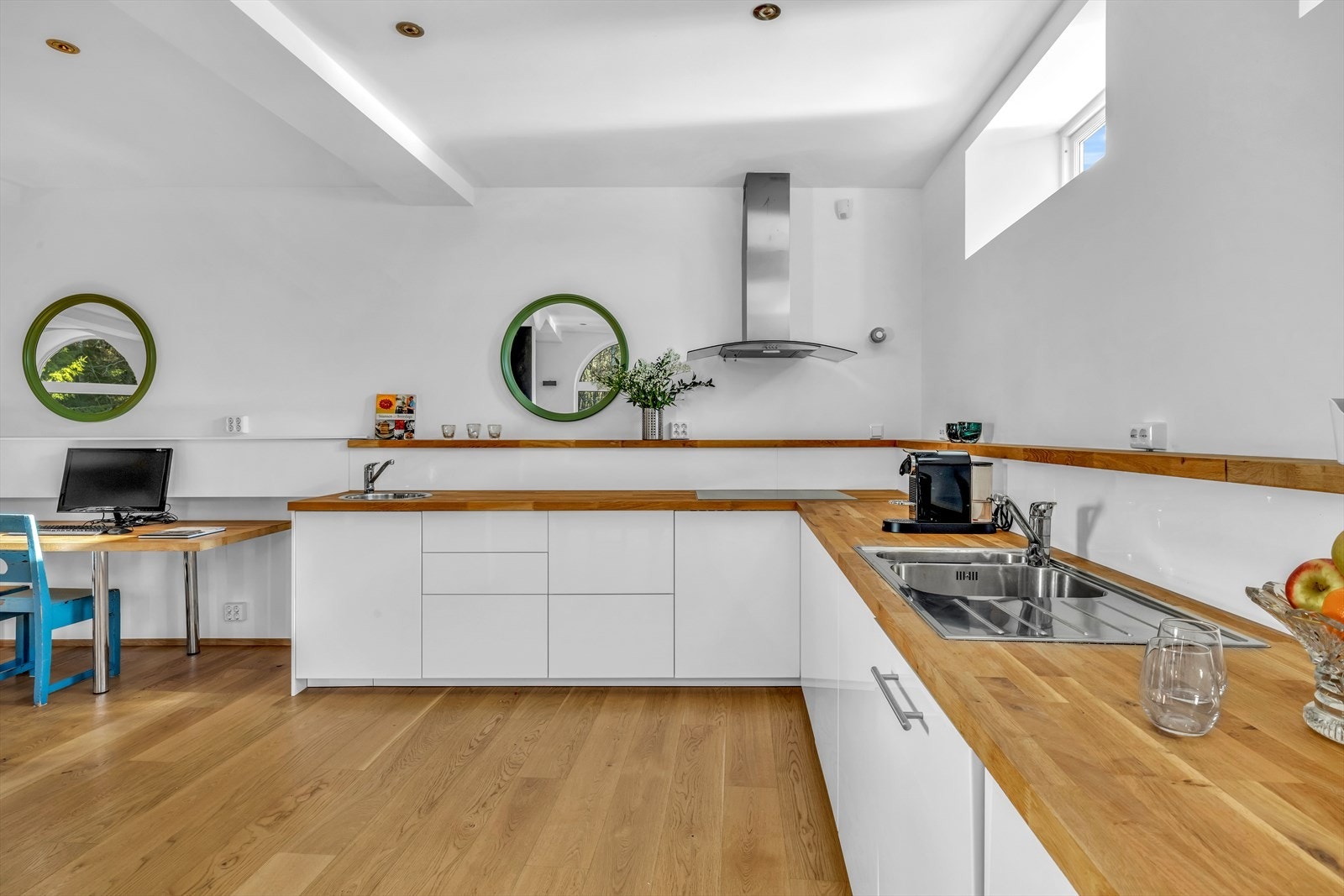 Kjøkkeninnredning med fronter i høyglanset utførelse. Heltre benkeplate med nedfelt kum i rustfritt stål. Automatisk vannstopper og komfyrvakt er montert. Galleribilde