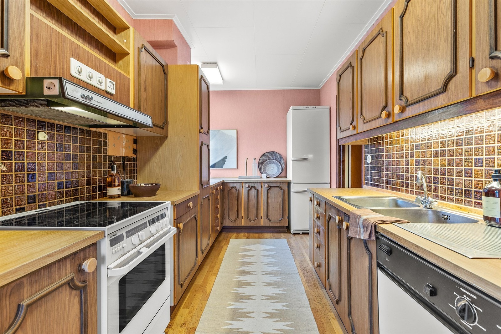 Kjøkkeninnredning med profilerte fronter. Benkeplate av laminat med nedfelt oppvaskkum av rustfritt stål med to-greps armatur. Galleribilde