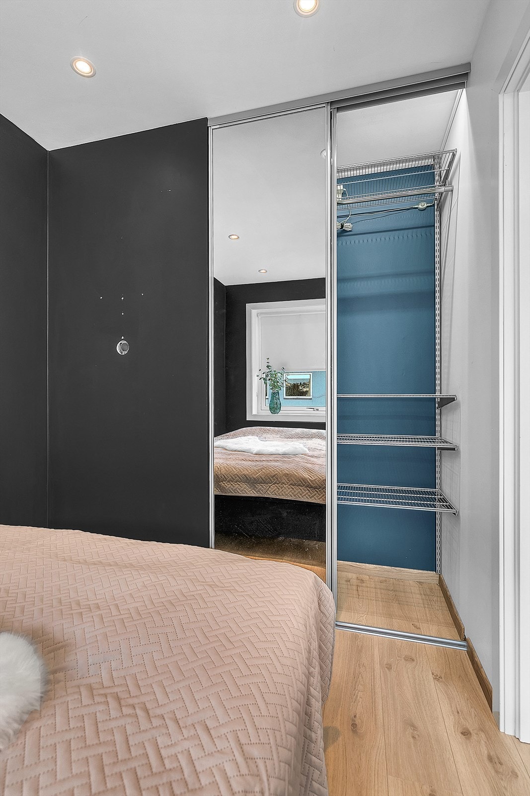 Det er skyvdørsgarderobe med oppheng i soverom Galleribilde