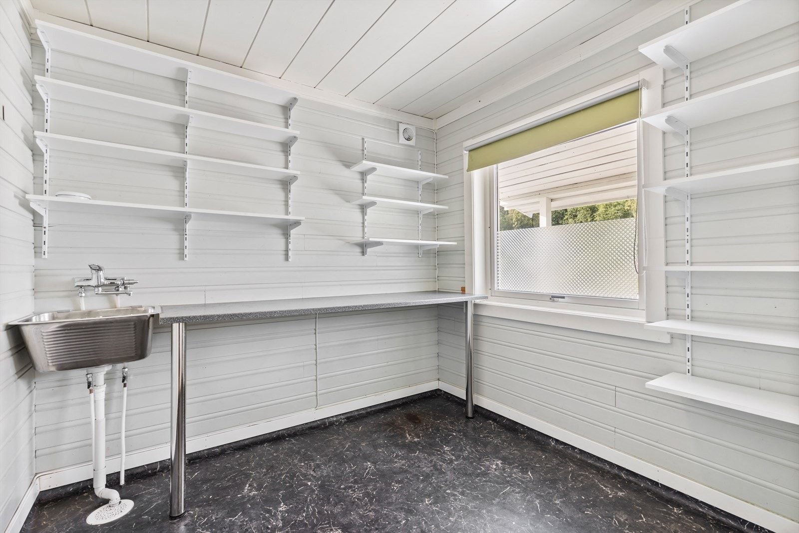 Vaskerommet med god plass til vaskemaskin og tørkerommel under benk - praktisk plassering av vaskerommet med inngang fra entrè Galleribilde