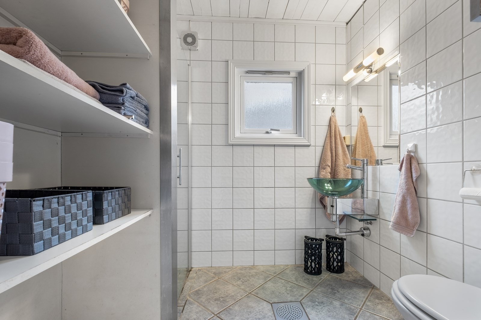 Badet har vegghengt toalett, glass-servant ... Galleribilde