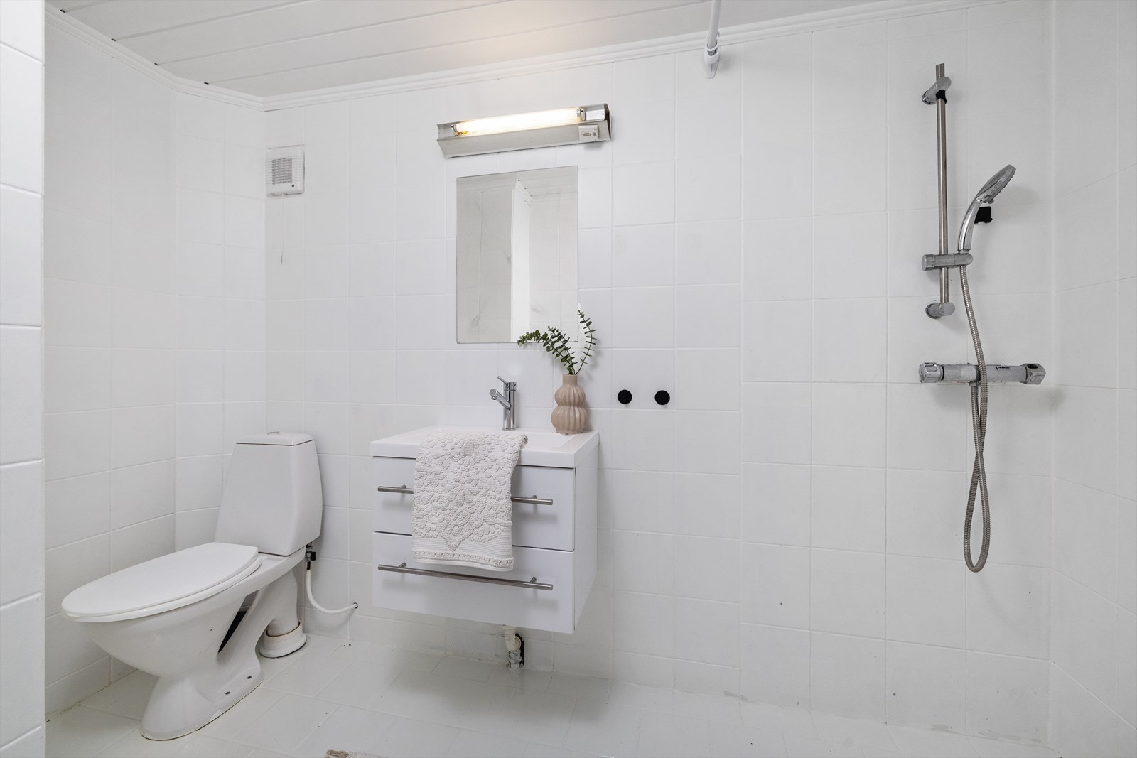 Bad 1. etasje med sanitærutstyr bestående av toalett, innredning med nedfelt servant, dusj og opplegg for vaskemaskin. Galleribilde