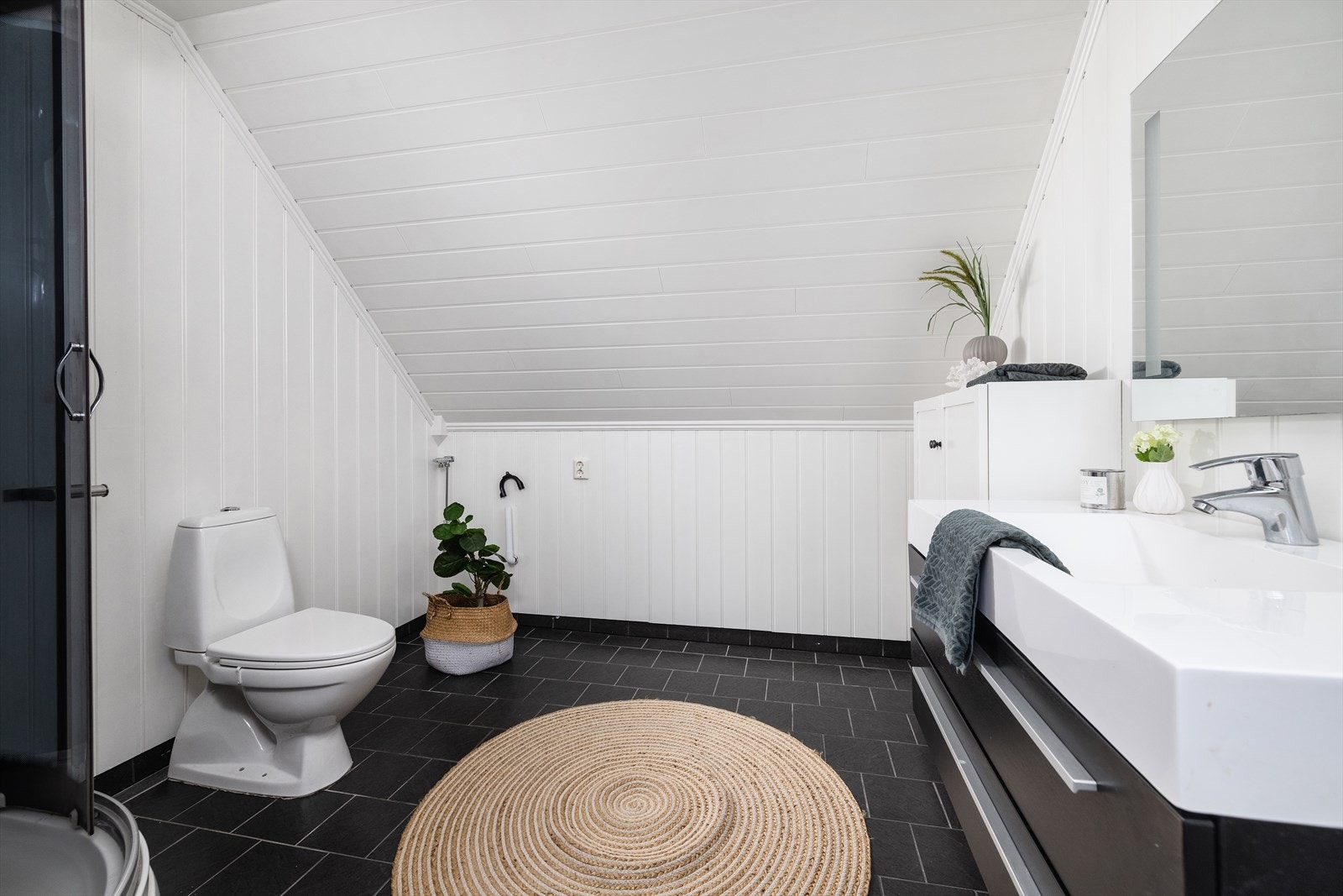 Bad 2. etasje har sanitærutstyr bestående av innredning med nedfelt servant, toalett, dusjkabinett og opplegg for vaskemaskin. Galleribilde