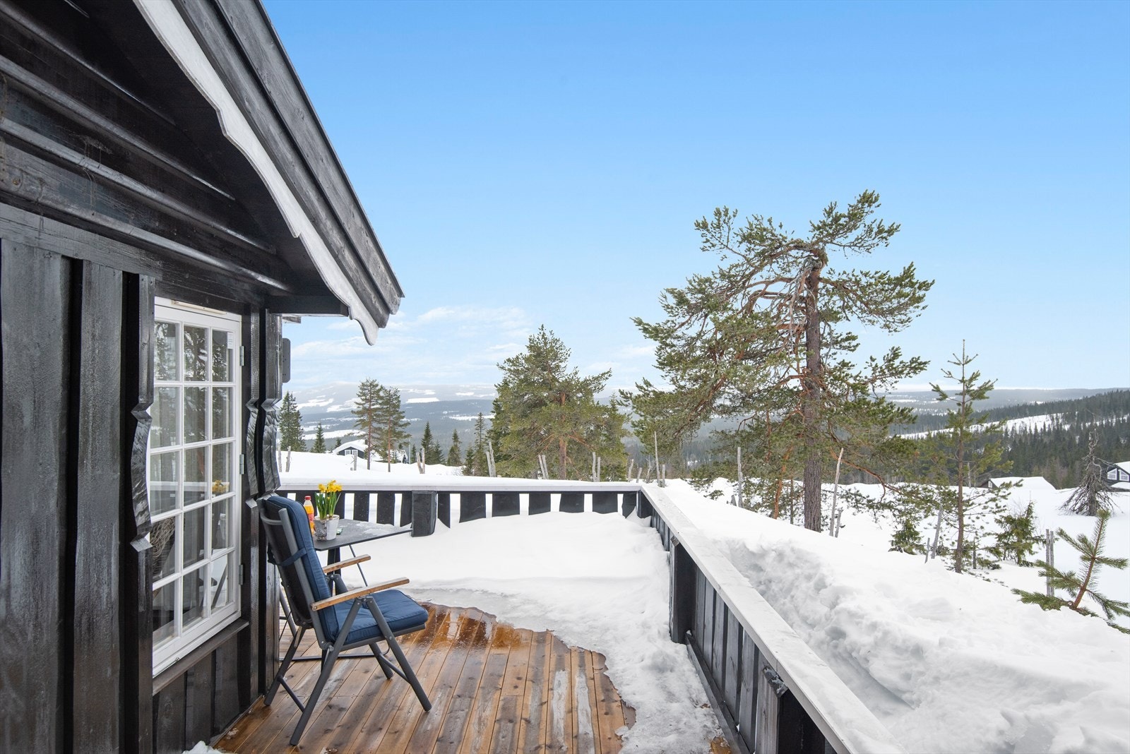 Terrassen har impregnerte terrassebord fra 2022. Skyvedør i glass fra den overbygde delen og ned til den åpne delen av terrassen. Galleribilde