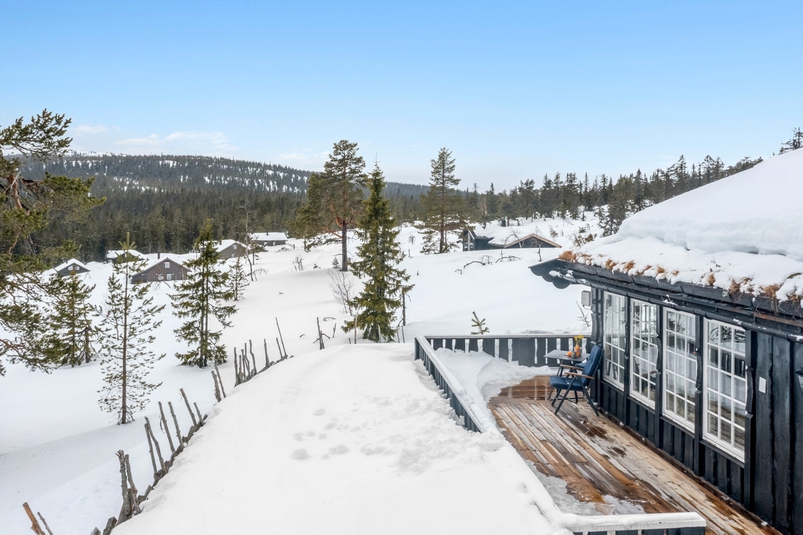 Terrassen har impregnerte terrassebord fra 2022. Skyvedør i glass fra den overbygde delen og ned til den åpne delen av terrassen. Galleribilde