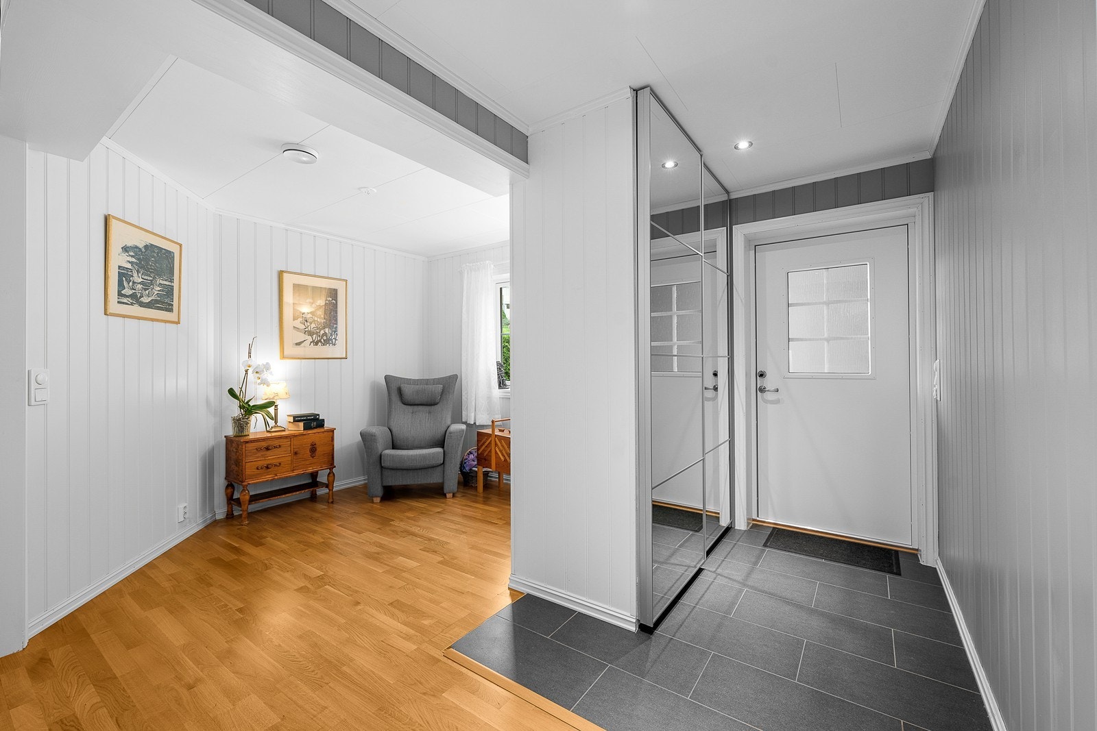Velkommen inn! Innbydende entré med god plass til oppbevaring av sko og yttertøy i en praktisk skyvedørsgarderobe med speilfronter. Galleribilde