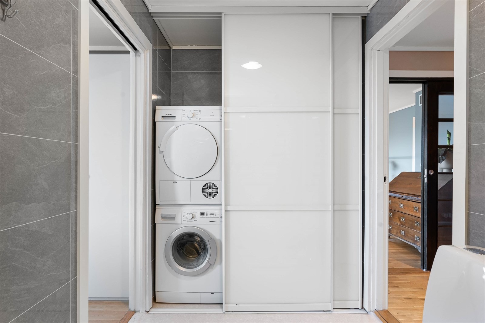 Praktisk løsning for vaskemaskin og tørketrommel bak skyvedører Galleribilde