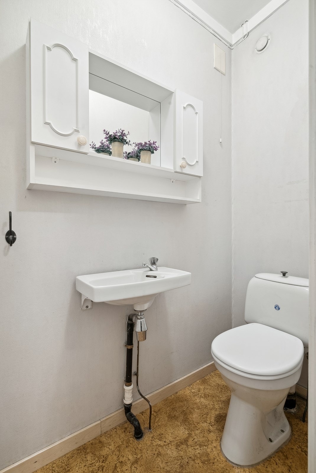 Wc-rommet inneholder speil med oppbevaringsskap, servant og toalett. Galleribilde