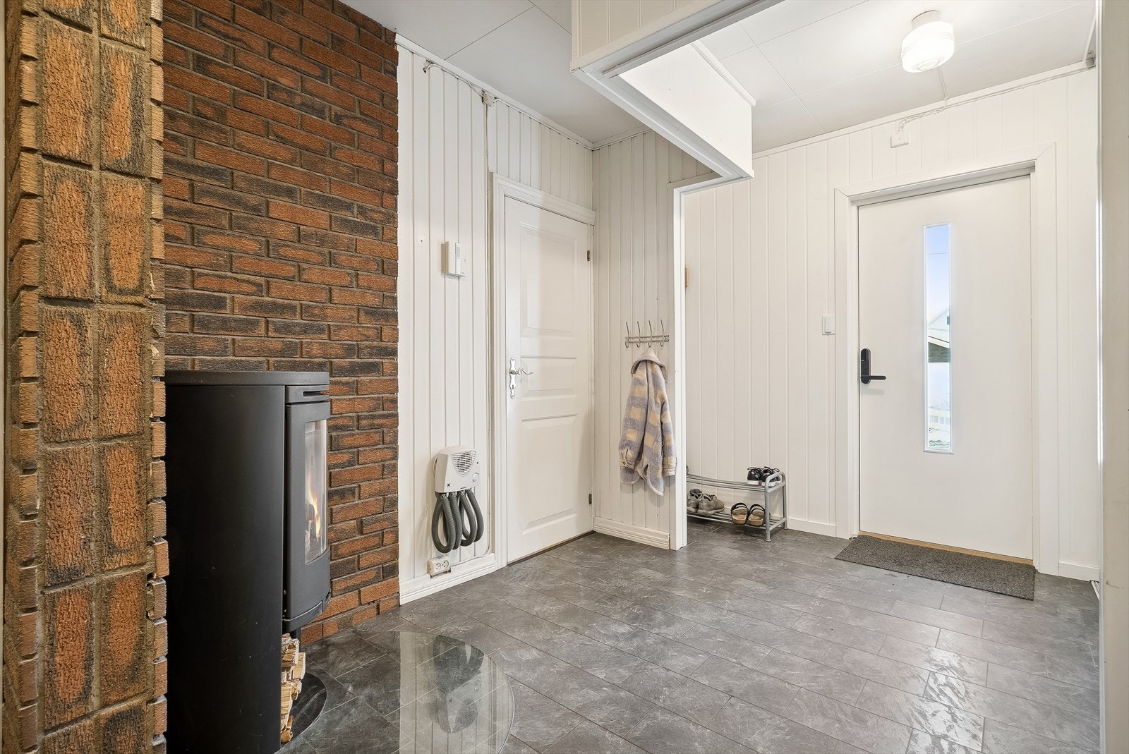 I gangen er det etablert både skyvedørsgarderobe og peis som gir lun og god varme. Galleribilde