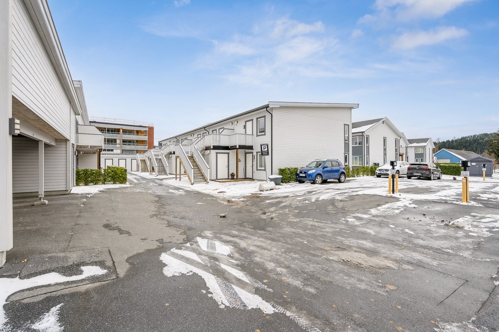 Asfalterte internveier og parkeringsområder. Leiligheten har tilhørende plass i carport til bilen. Det er også en stor tilhørende utvendig bod. Galleribilde