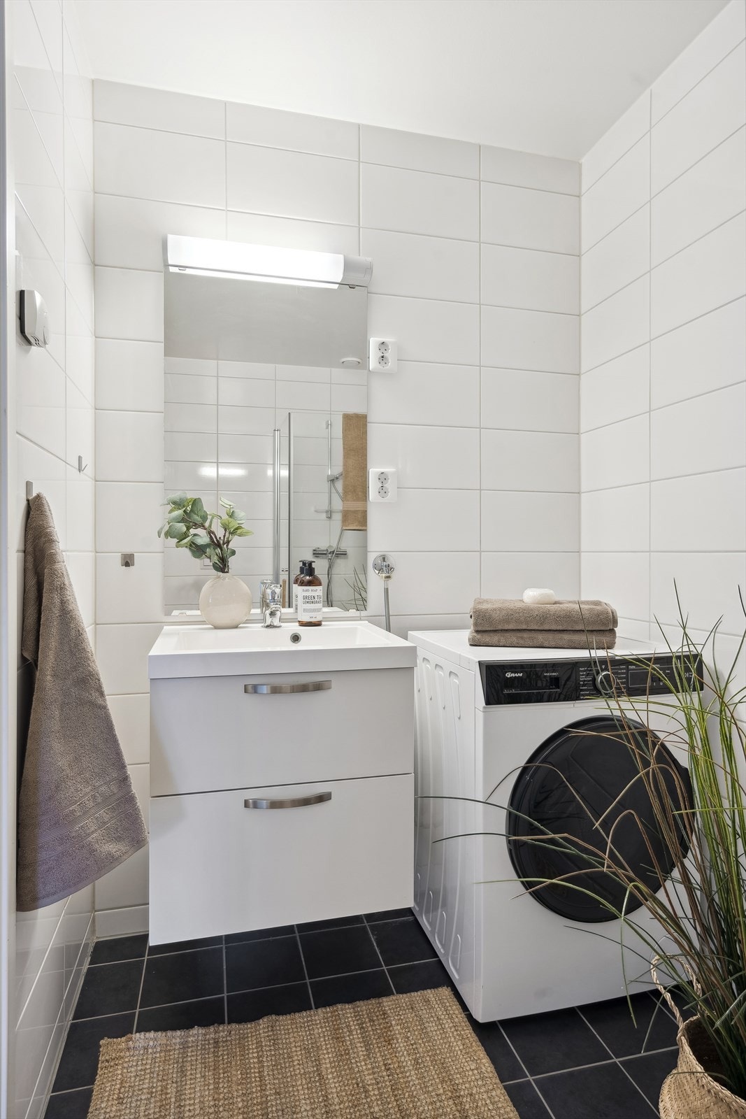 Det lyse delikate flislagte badet inneholder alt man måtte trenge. Vaskemaskinen kan medfølge i handelen om ønskelig. Galleribilde