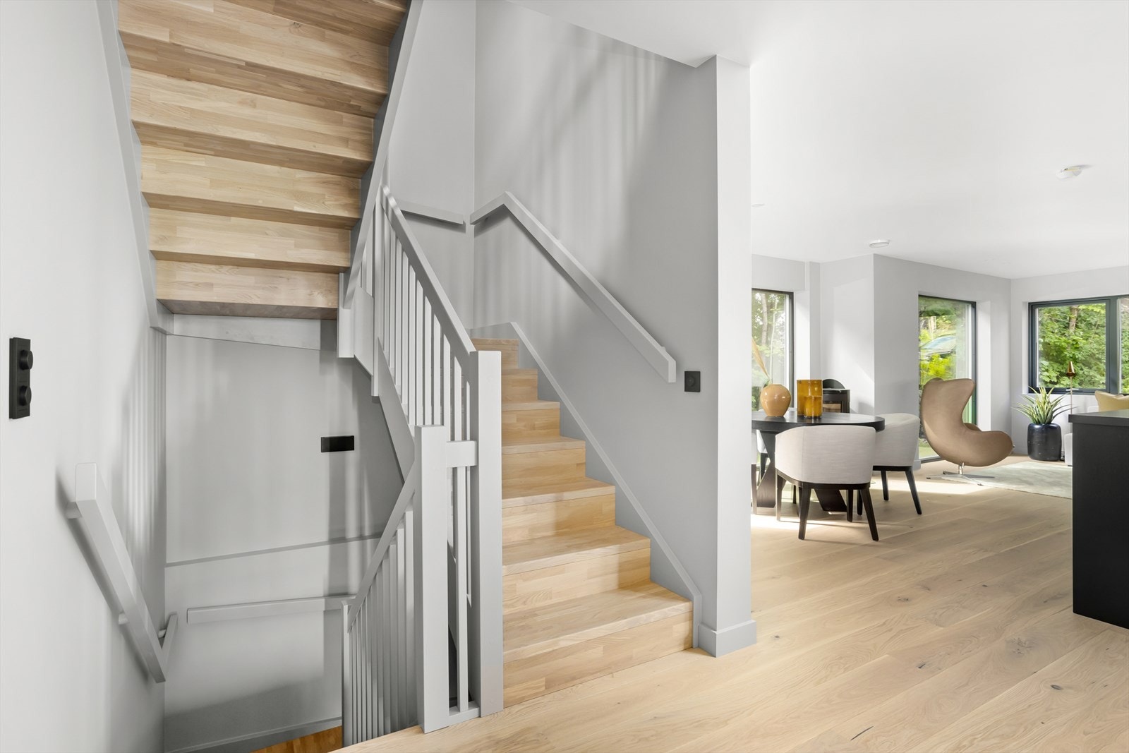 Innvendige trapper med eiketrinn og grå glaserte furuvanger, stolper og håndløpere. Galleribilde